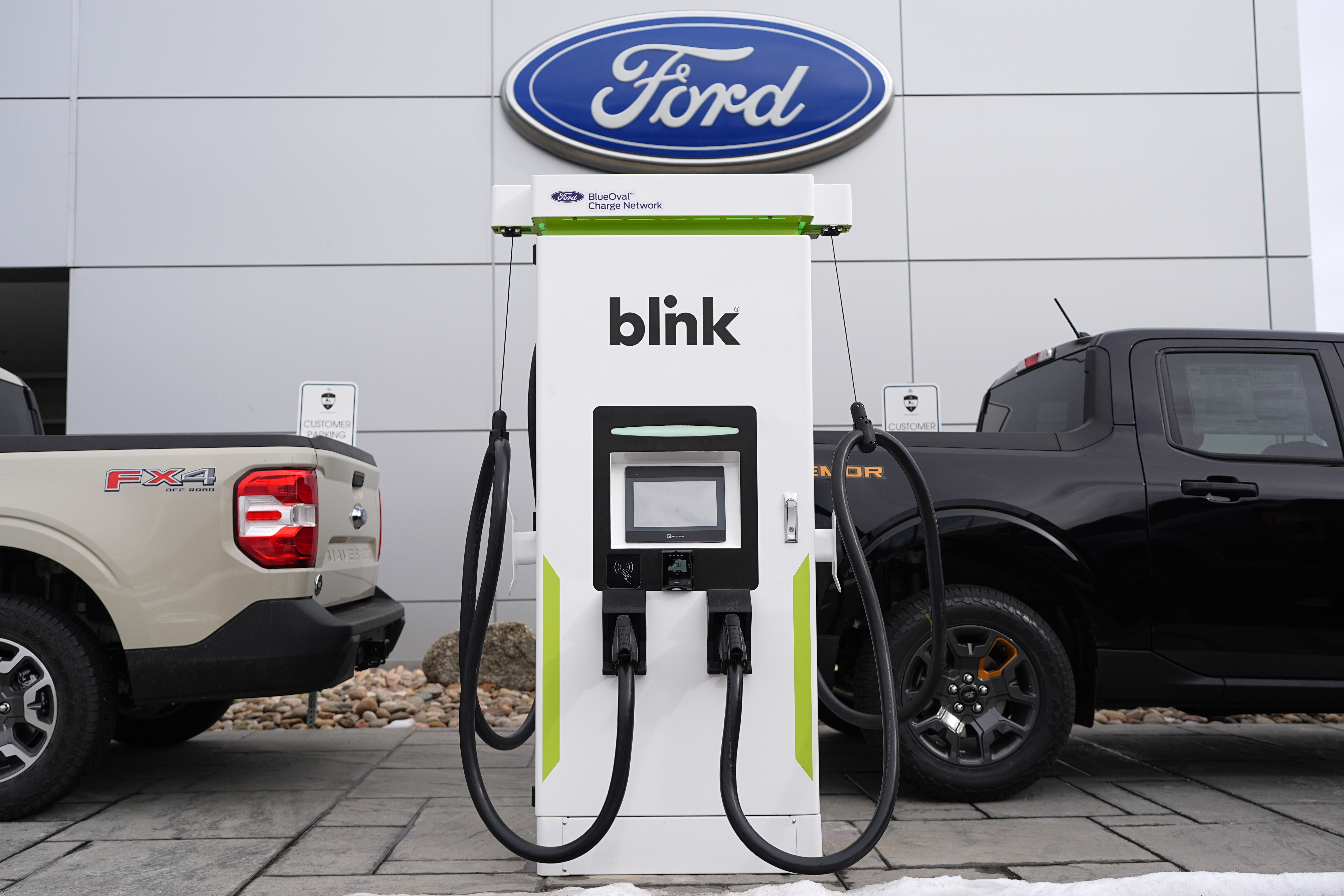 FILE - Electric vehicle chargers sit outside a Ford dealership, Jan. 21, 2024, in Broomfield, Colo. (AP Photo/David Zalubowski, File)