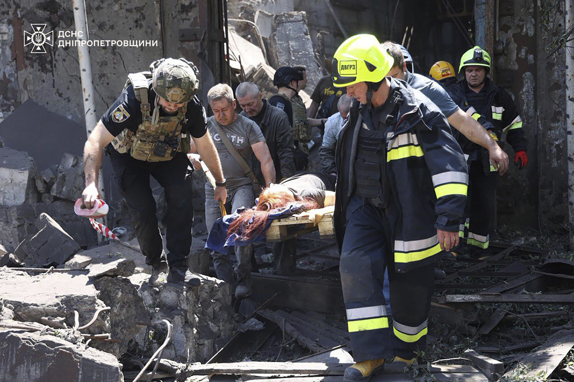 In this photo provided by the Ukrainian Emergency Service, rescuers carry an injured civilian following Russia's missile attack in Dnipro, Ukraine, Tuesday, June 24, 2025. (Ukrainian Emergency Service via AP)