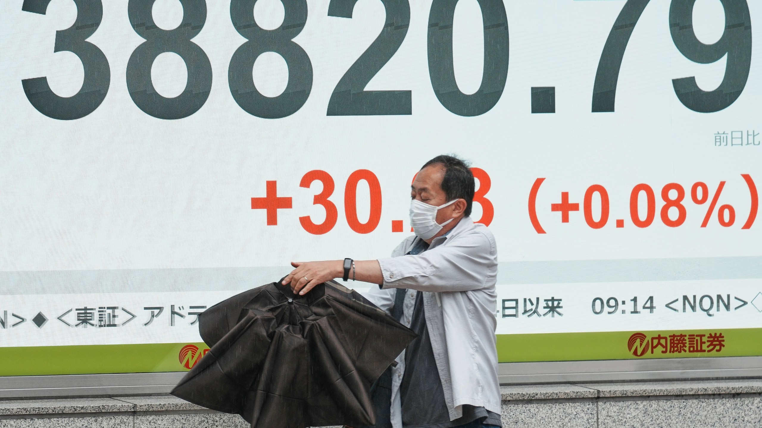 A person walks in front of an electronic stock board showing Japan's Nikkei index at a securities firm Wednesday, June 25, 2025, in Tokyo. (AP Photo/Eugene Hoshiko)