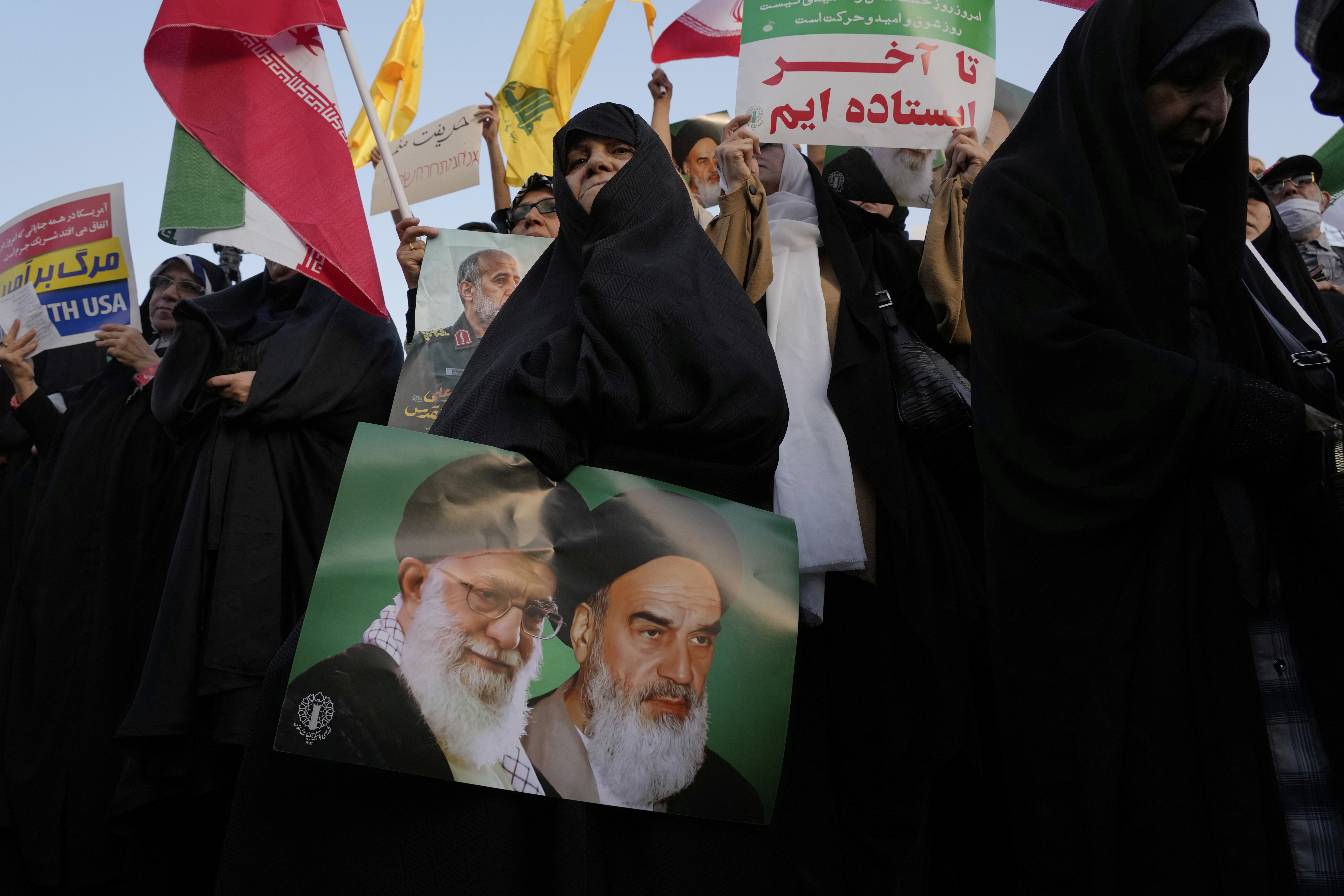 An Iranian woman holds a poster of the late revolutionary founder Ayatollah Khomeini, right, and Supreme Leader Ayatollah Ali Khamenei in an anti-U.S. and anti-Israeli rally at Enqelab-e-Eslami (Islamic Revolution) square in downtown Tehran, Iran, Tuesday, June 24, 2025. (AP Photo/Vahid Salemi)