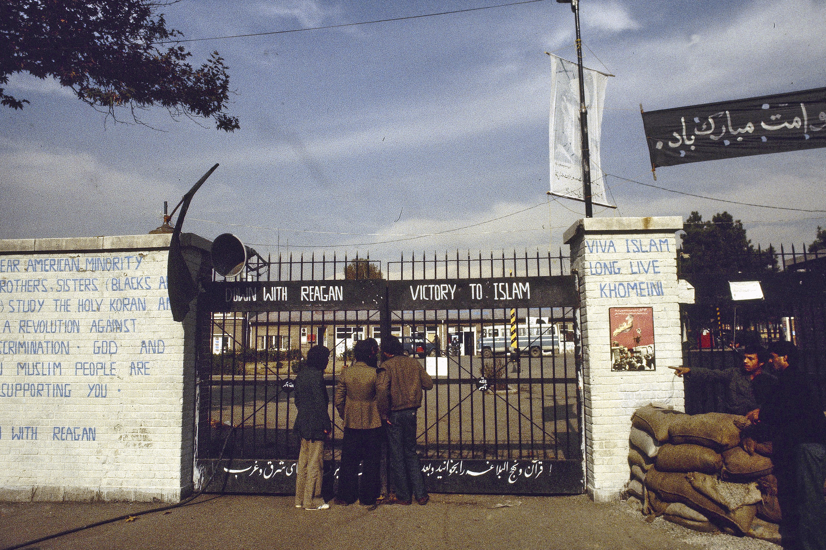 FILE - The entrance to the U.S. Embassy in Tehran, Iran, where 63 people are being held hostage, seen in 1980. Graffiti on the wall at left reads: "Dear American minority, brothers and sisters (Blacks and Indians) study the holy Koran and start a revolution against U.S. discrimination. God and Iranian Muslim people are supporting you. Down with Reagan." (AP Photo, File)