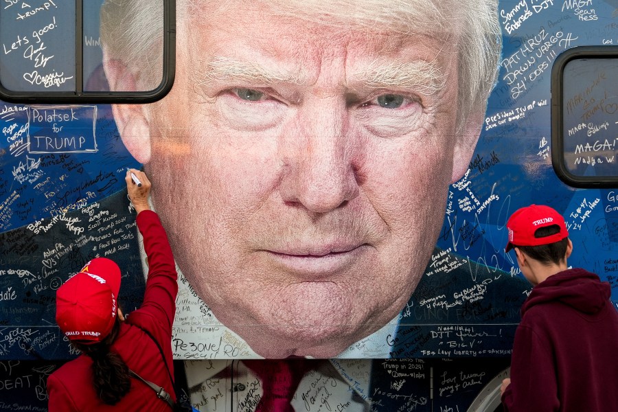 FILE - Supporters of Republican presidential nominee former President Donald Trump sign a bus before a campaign rally at the Butler Farm Show, Oct. 5, 2024, in Butler, Pa. (AP Photo/Julia Demaree Nikhinson, File)