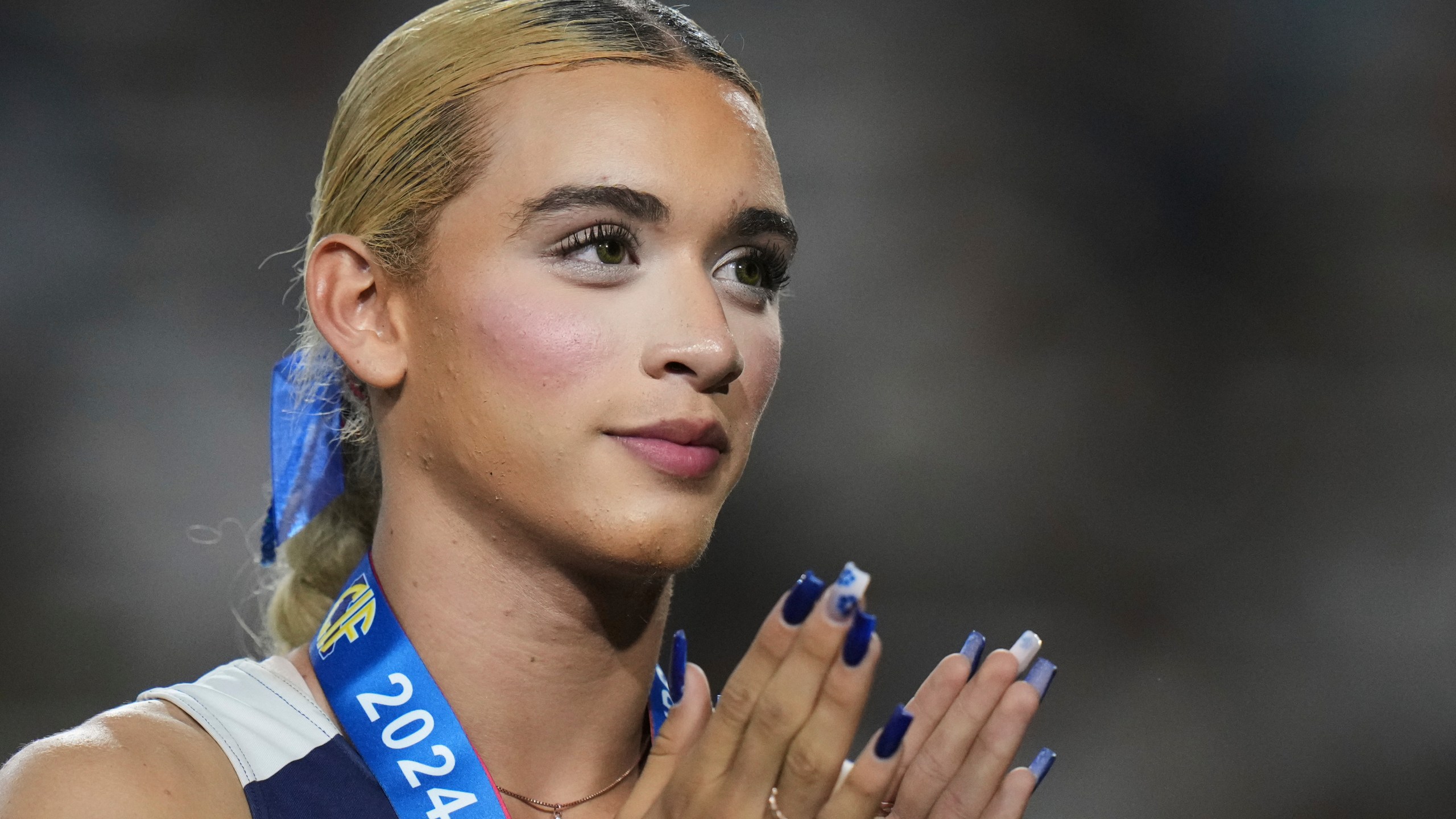 FILE - AB Hernandez, a transgender student at Jurupa Valley High School, stands on the podium during a medal ceremony for the triple jump at the California high school track-and-field championships in Clovis, Calif., May 31, 2025. (AP Photo/Jae C. Hong, file)