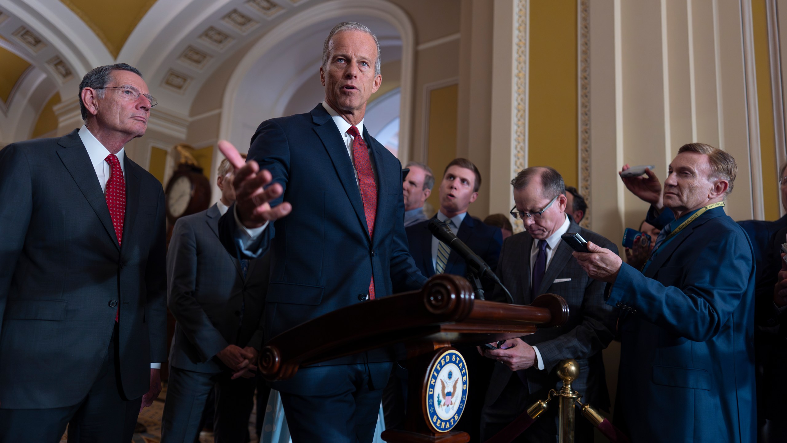 Senate Majority Leader John Thune, R-S.D., center, joined at left by Sen. John Barrasso, R-Wyo., the GOP whip, speaks to reporters after Republican senators met with Treasury Secretary Scott Bessent and worked on President Donald Trump's tax and immigration megabill so they can have on his desk by July 4, at the Capitol in Washington, Tuesday, June 24, 2025. (AP Photo/J. Scott Applewhite)