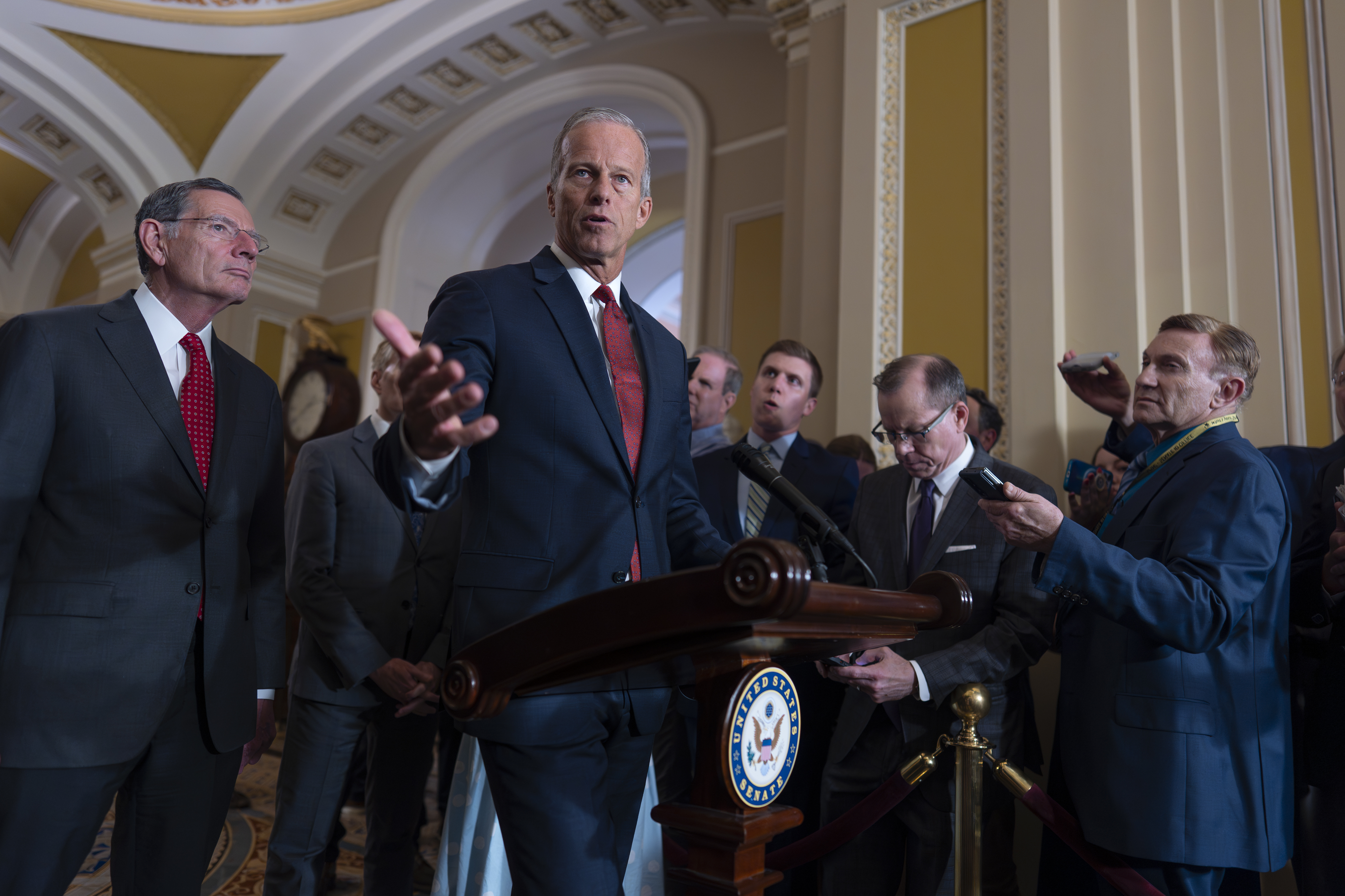 Senate Majority Leader John Thune, R-S.D., center, joined at left by Sen. John Barrasso, R-Wyo., the GOP whip, speaks to reporters after Republican senators met with Treasury Secretary Scott Bessent and worked on President Donald Trump's tax and immigration megabill so they can have on his desk by July 4, at the Capitol in Washington, Tuesday, June 24, 2025. (AP Photo/J. Scott Applewhite)