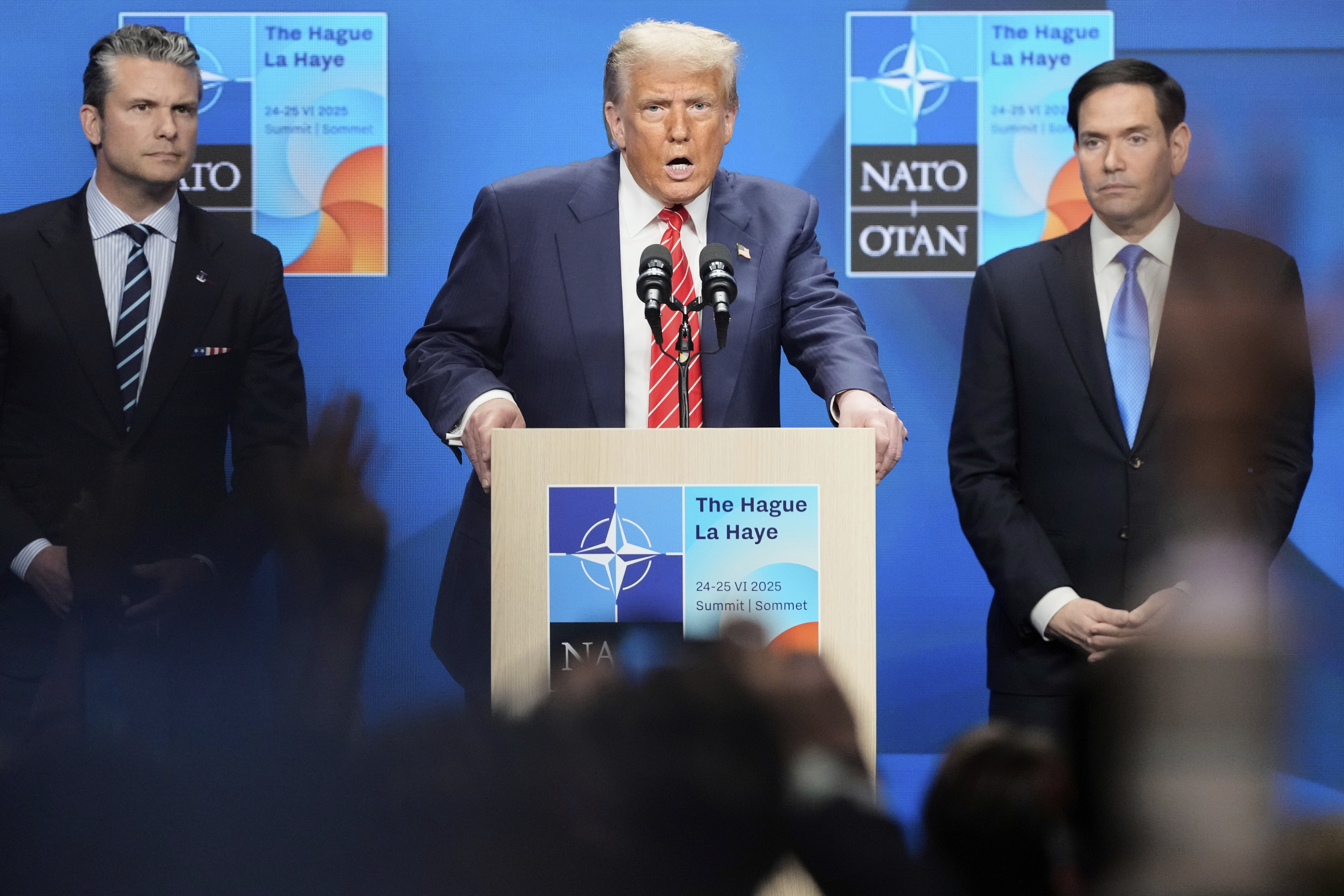 President Donald Trump speaks standing between Secretary of State Marco Rubio, right, and Defense Secretary Pete Hegseth during a press conference after the plenary session at the NATO summit in The Hague, Netherlands, Wednesday, June 25, 2025. (AP Photo/Markus Schreiber)