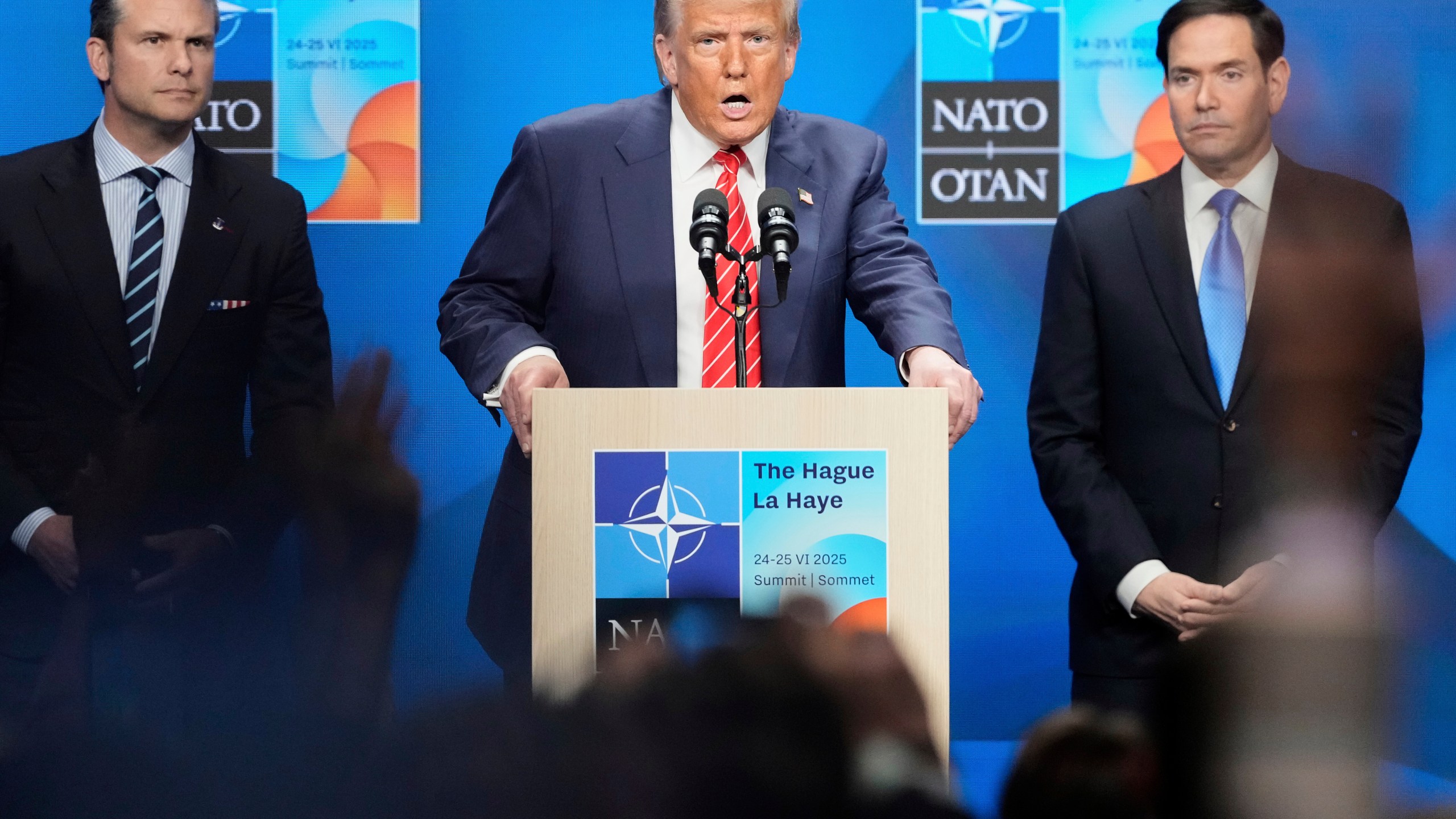 President Donald Trump speaks standing between Secretary of State Marco Rubio, right, and Defense Secretary Pete Hegseth during a press conference after the plenary session at the NATO summit in The Hague, Netherlands, Wednesday, June 25, 2025. (AP Photo/Markus Schreiber)