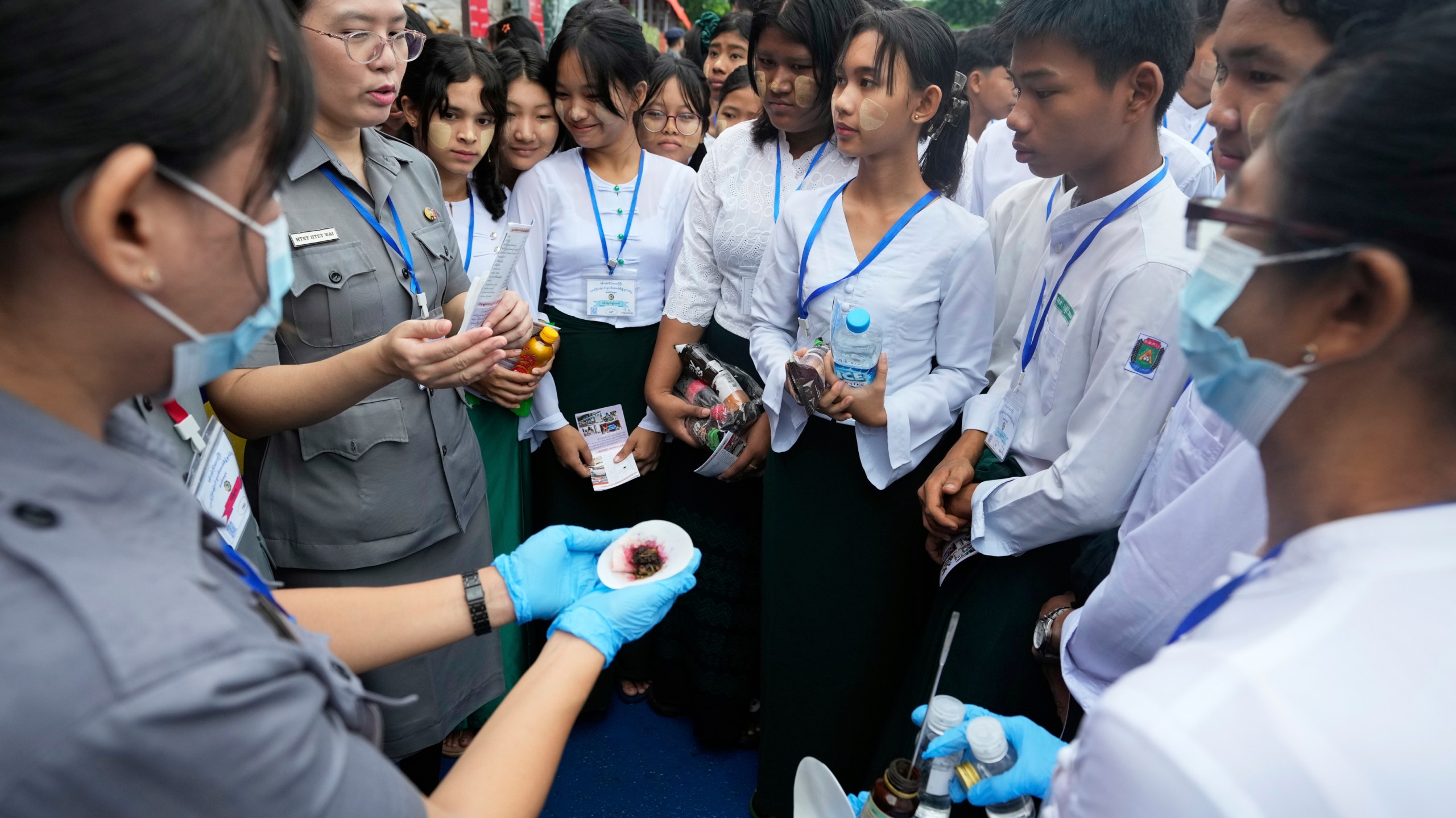 Police officers explain illegal narcotics to students during a destruction ceremony to mark International Day against Drug Abuse and Illicit Trafficking, on the outskirts of Yangon, Myanmar, Thursday, June 26, 2025. (AP Photo/Thein Zaw)