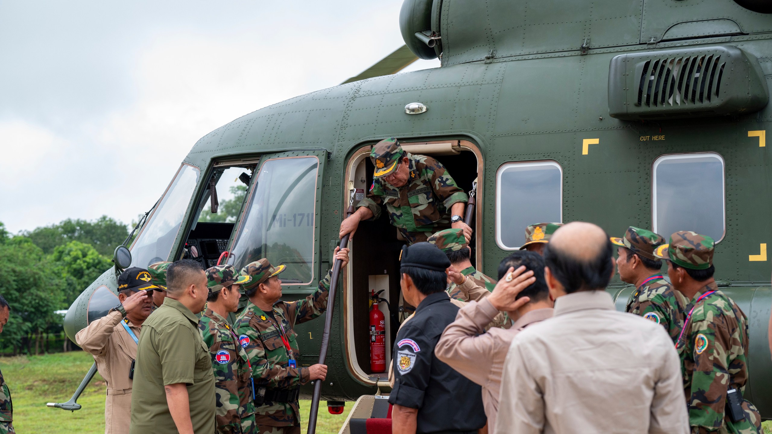 In this photo released by Agence Kampuchea Press (AKP), Cambodian Senate President Hun Sen, center, gets off from a helicopter during his visit to Oddar Meanchey province, near Cambodia-Thailand border of northern province of Cambodia, Thursday, June 26, 2025. (AKP via AP)