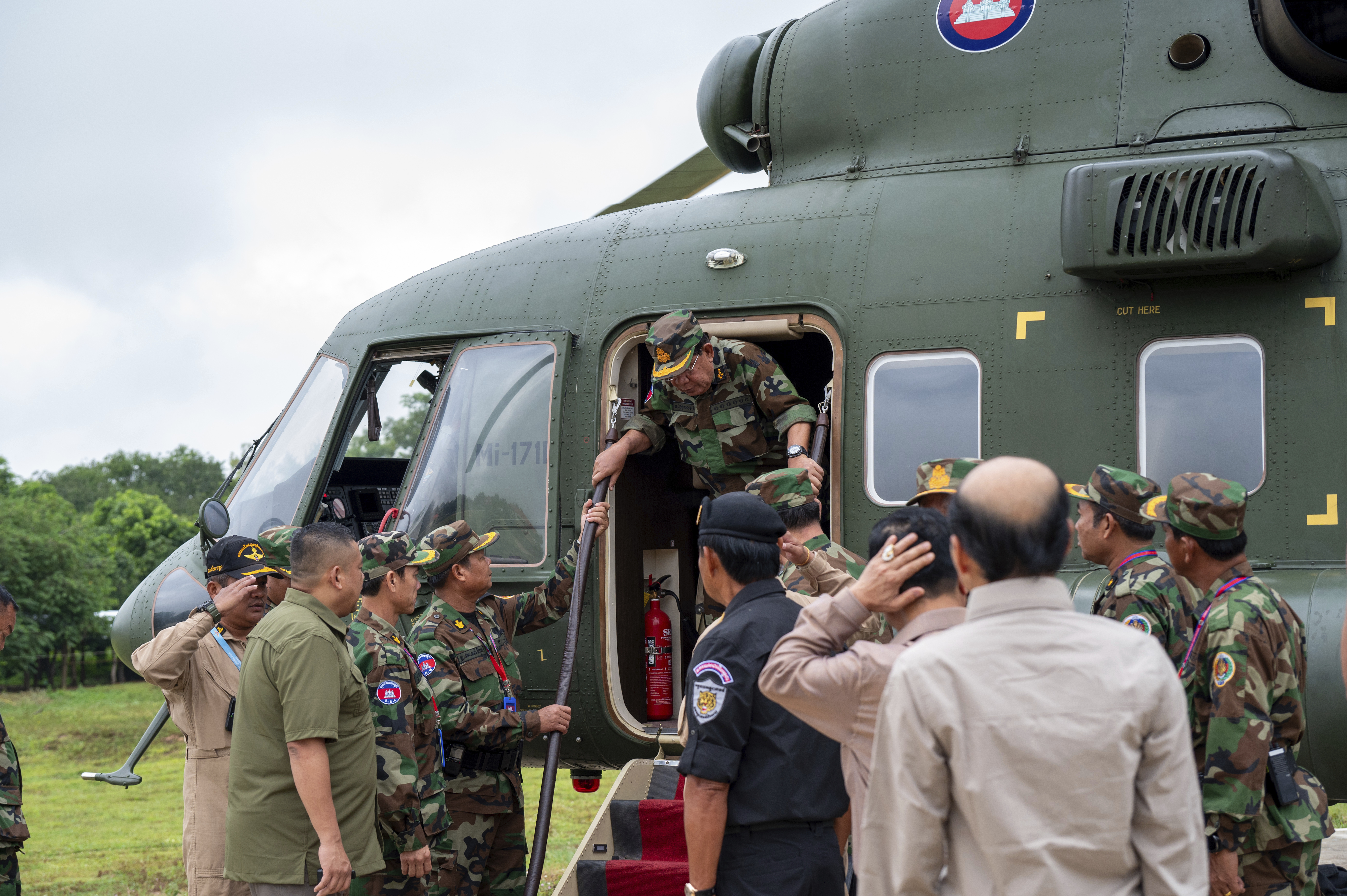 In this photo released by Agence Kampuchea Press (AKP), Cambodian Senate President Hun Sen, center, gets off from a helicopter during his visit to Oddar Meanchey province, near Cambodia-Thailand border of northern province of Cambodia, Thursday, June 26, 2025. (AKP via AP)