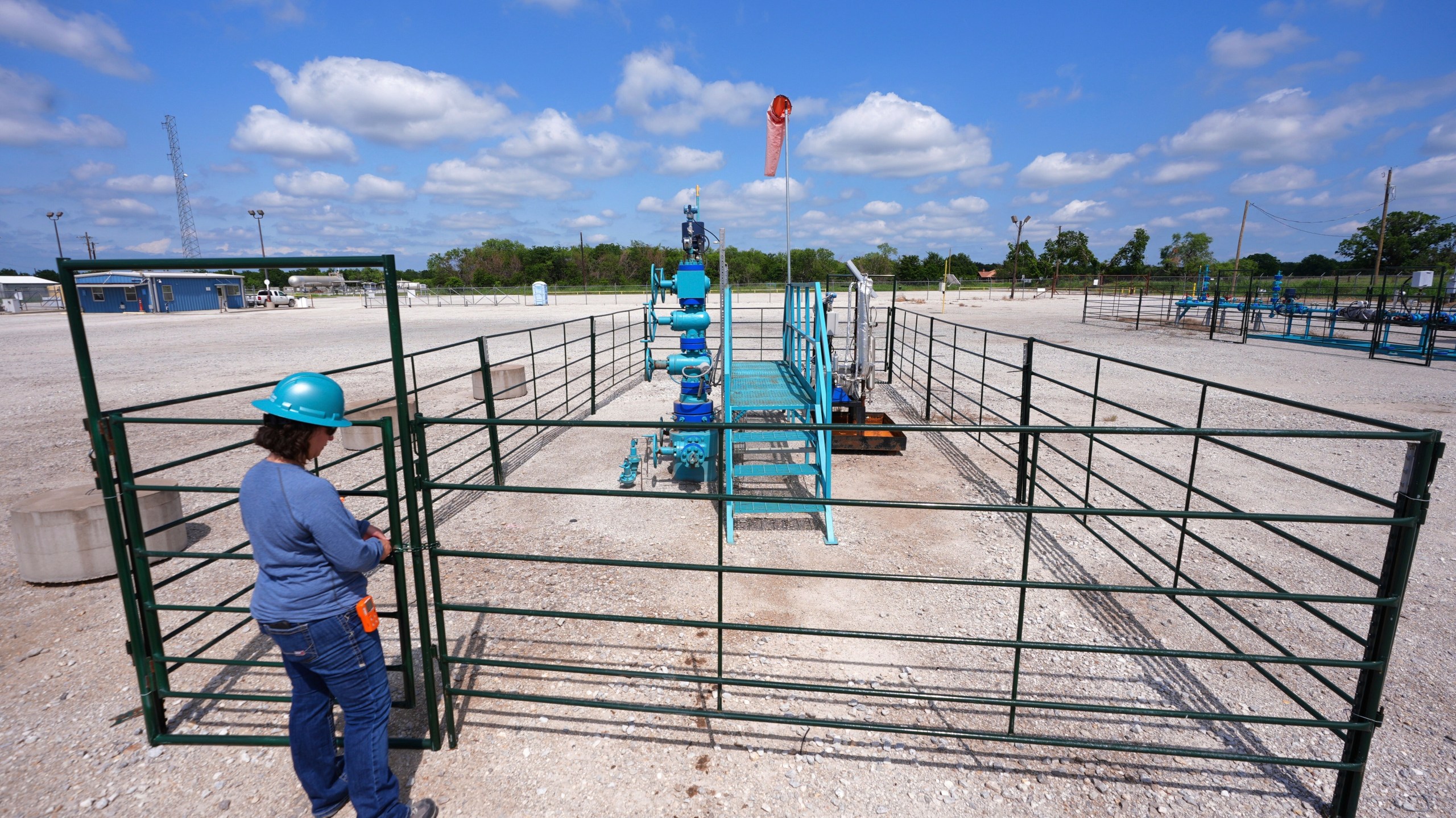 BKV Carbon Ventures senior facility engineer Laura Mamazza closes a gate on a carbon sequestration injection well pad site at a carbon capture and sequestration facility in Bridgeport, Texas, Thursday, May 29, 2025. (AP Photo/LM Otero)