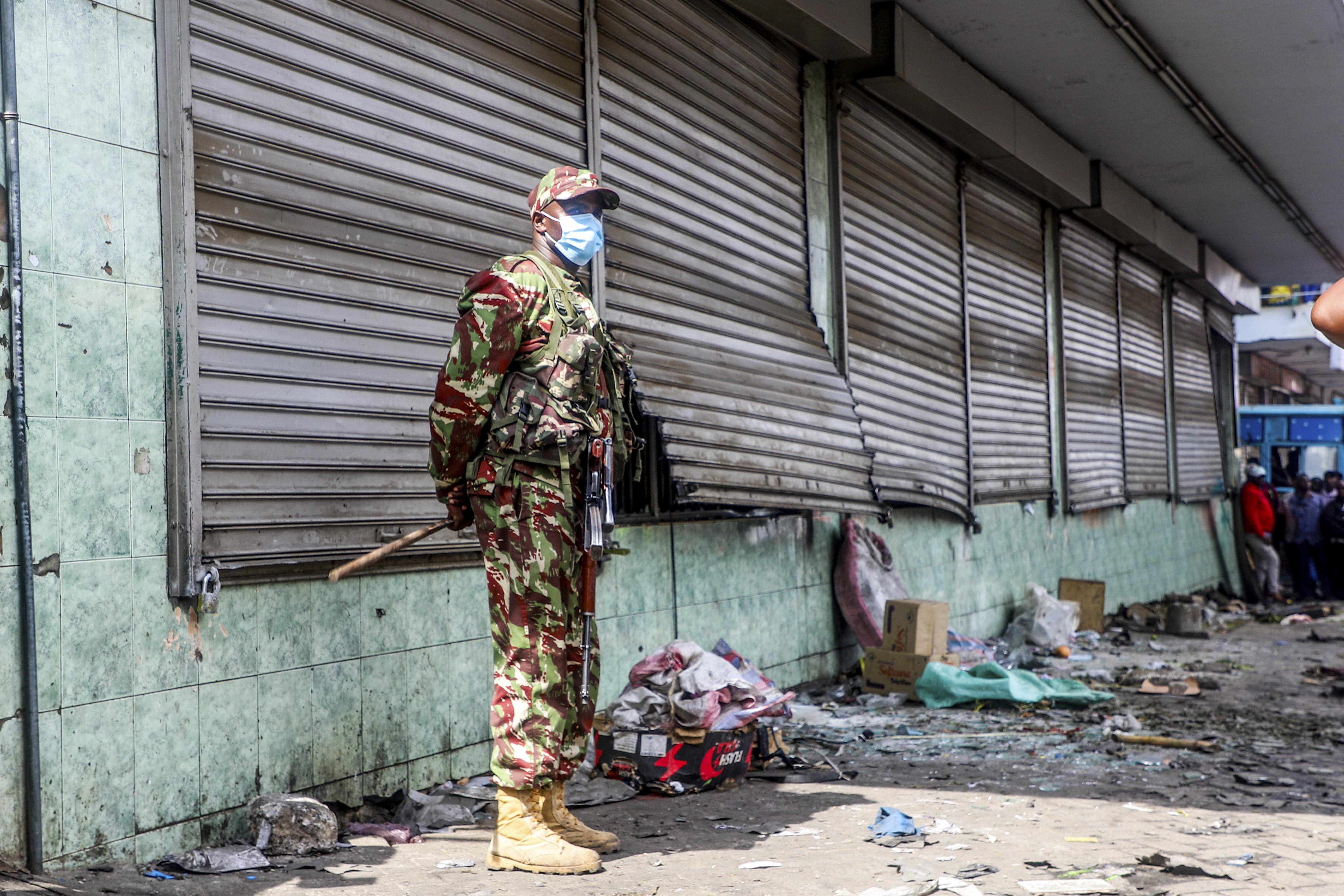 A police officer stands guard at a vandalized shop following the one-year anniversary of deadly anti-tax demonstrations in Nairobi, Kenya, Thursday, June 26, 2025. (AP Photo/Patrick Ngugi)