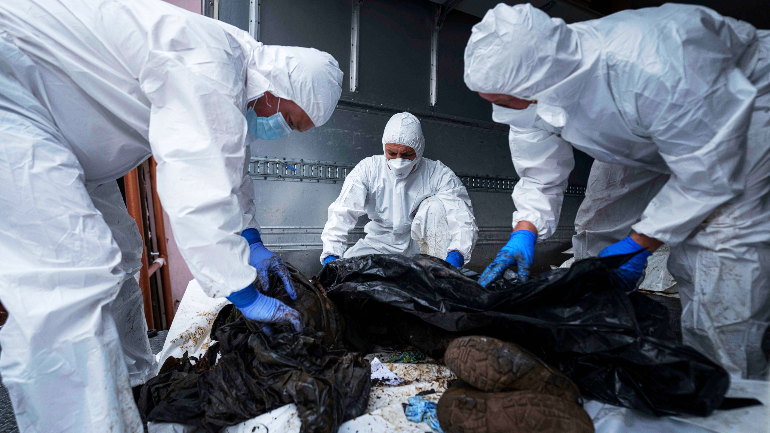 Ukrainian servicemen inspect a body of their comrade repatriated from Russia, at the morgue in Kyiv, Ukraine, on Thursday, June 26, 2025. (AP Photo/Evgeniy Maloletka)
