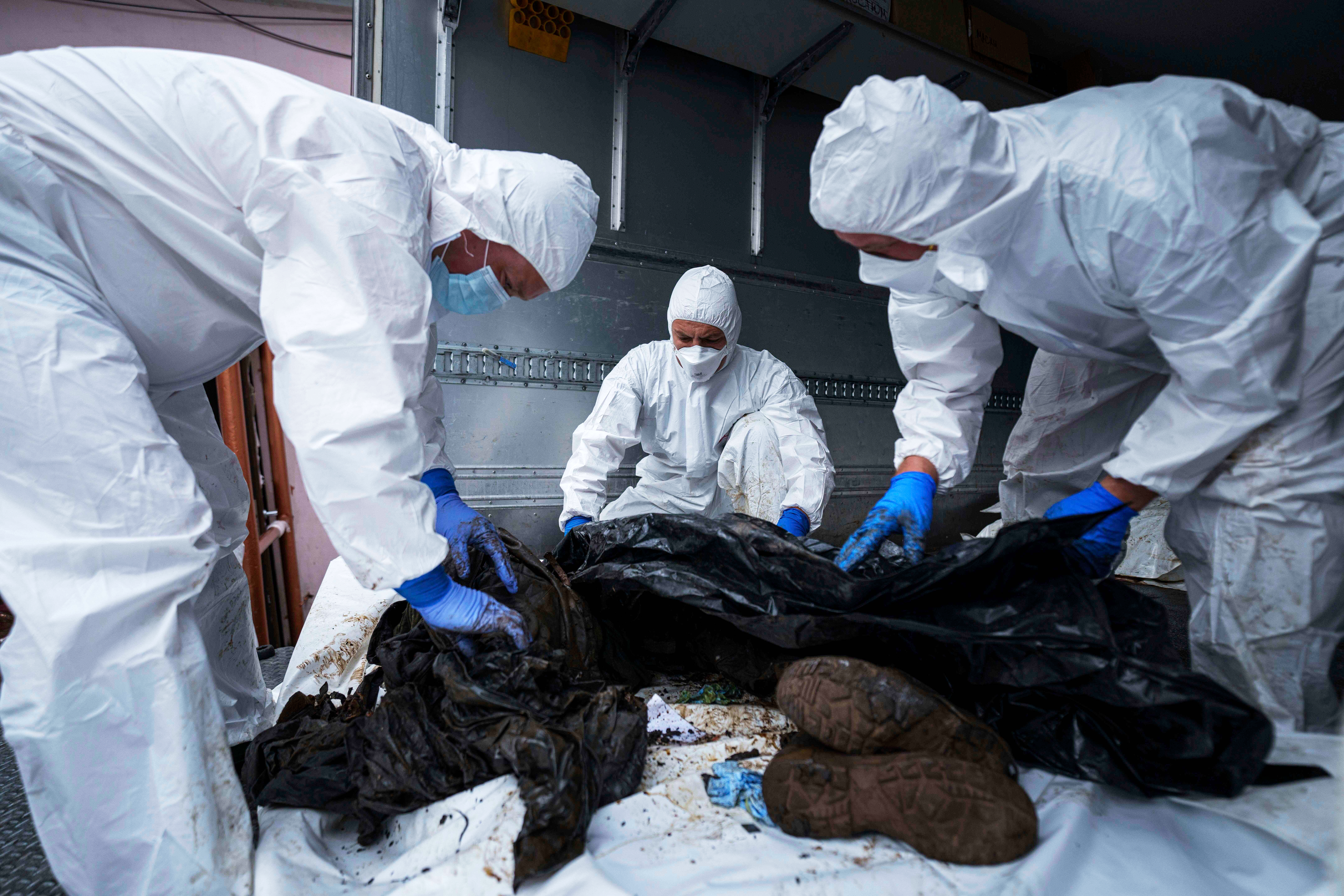 Ukrainian servicemen inspect a body of their comrade repatriated from Russia, at the morgue in Kyiv, Ukraine, on Thursday, June 26, 2025. (AP Photo/Evgeniy Maloletka)