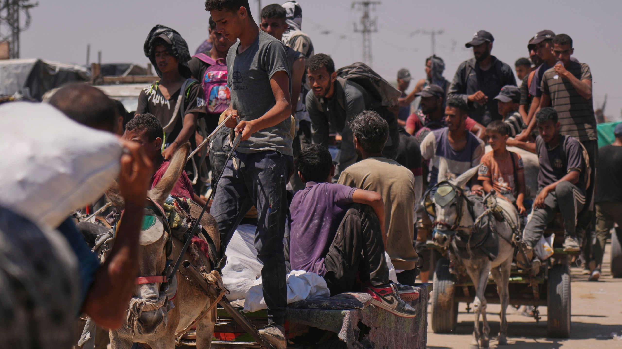 Palestinians carry bags containing food and humanitarian aid packages delivered by the Gaza Humanitarian Foundation, a U.S.-backed organization, in Rafah, southern Gaza Strip, Wednesday, June 25, 2025. (AP Photo/Abdel Kareem Hana)