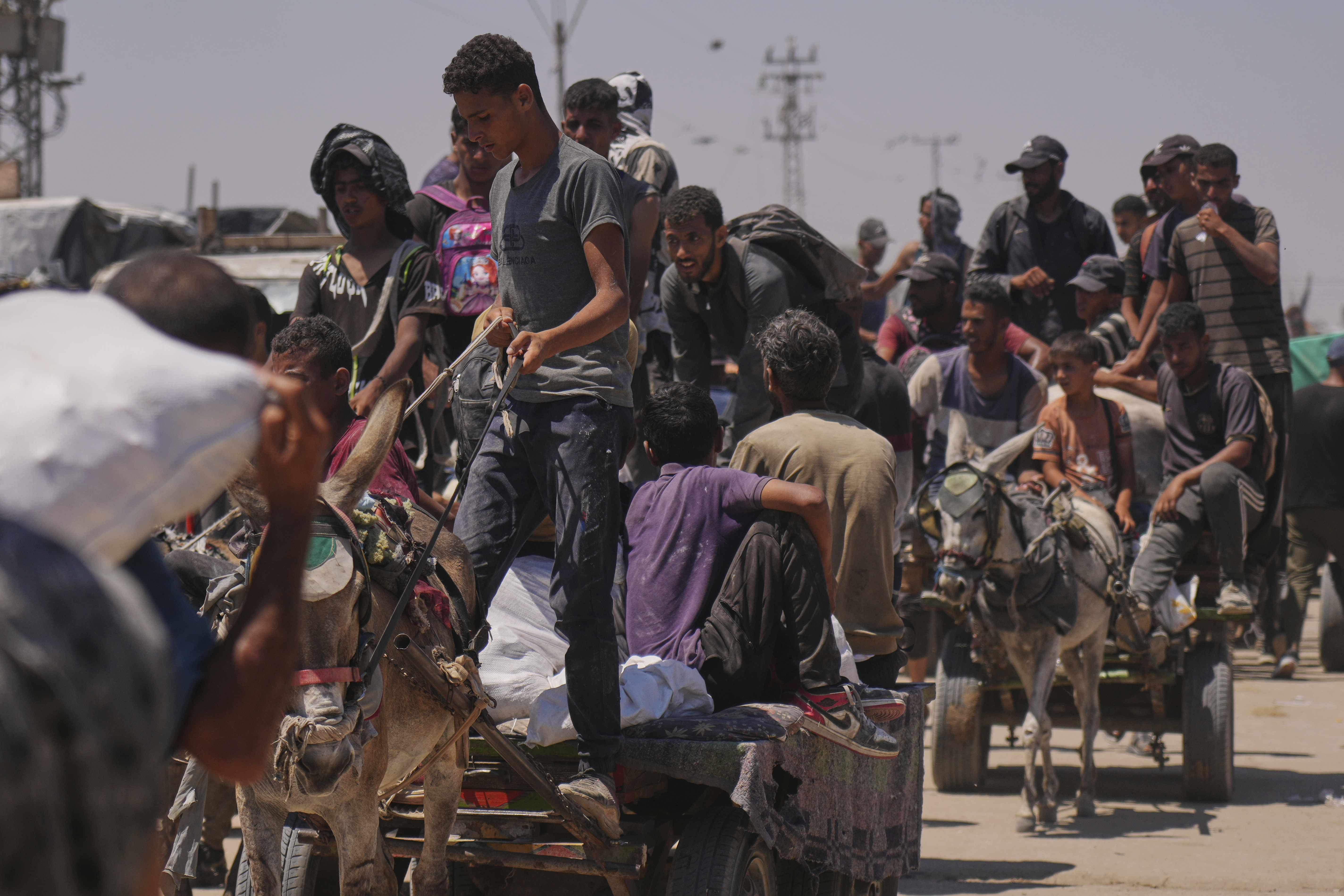 Palestinians carry bags containing food and humanitarian aid packages delivered by the Gaza Humanitarian Foundation, a U.S.-backed organization, in Rafah, southern Gaza Strip, Wednesday, June 25, 2025. (AP Photo/Abdel Kareem Hana)