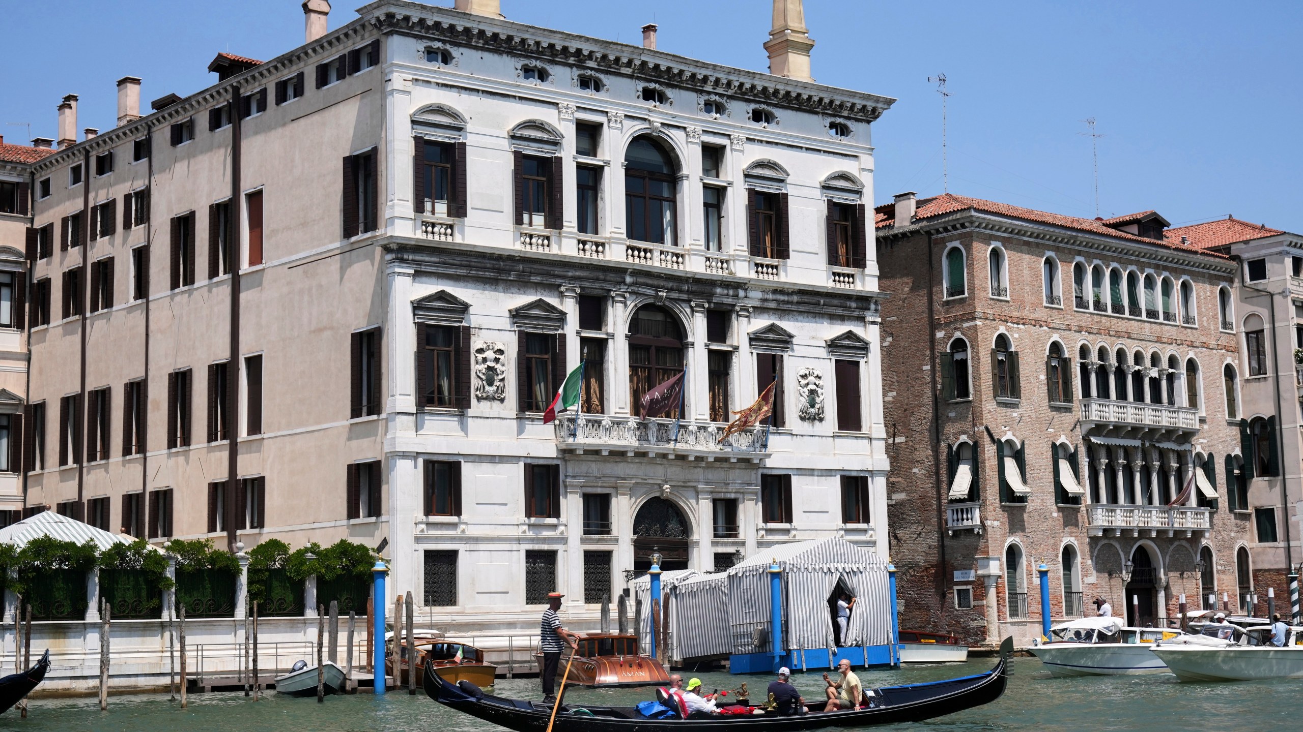 CORRECTS TO AMAN HOTEL NOT ANNAN A gondola sails past the Aman Hotel in Venice, Italy, on Thursday, June 26, 2025, ahead of festivities in the lagoon city reportedly linked to a wedding celebration for Jeff Bezos and Lauren Sánchez. (AP Photo/Antonio Calanni)