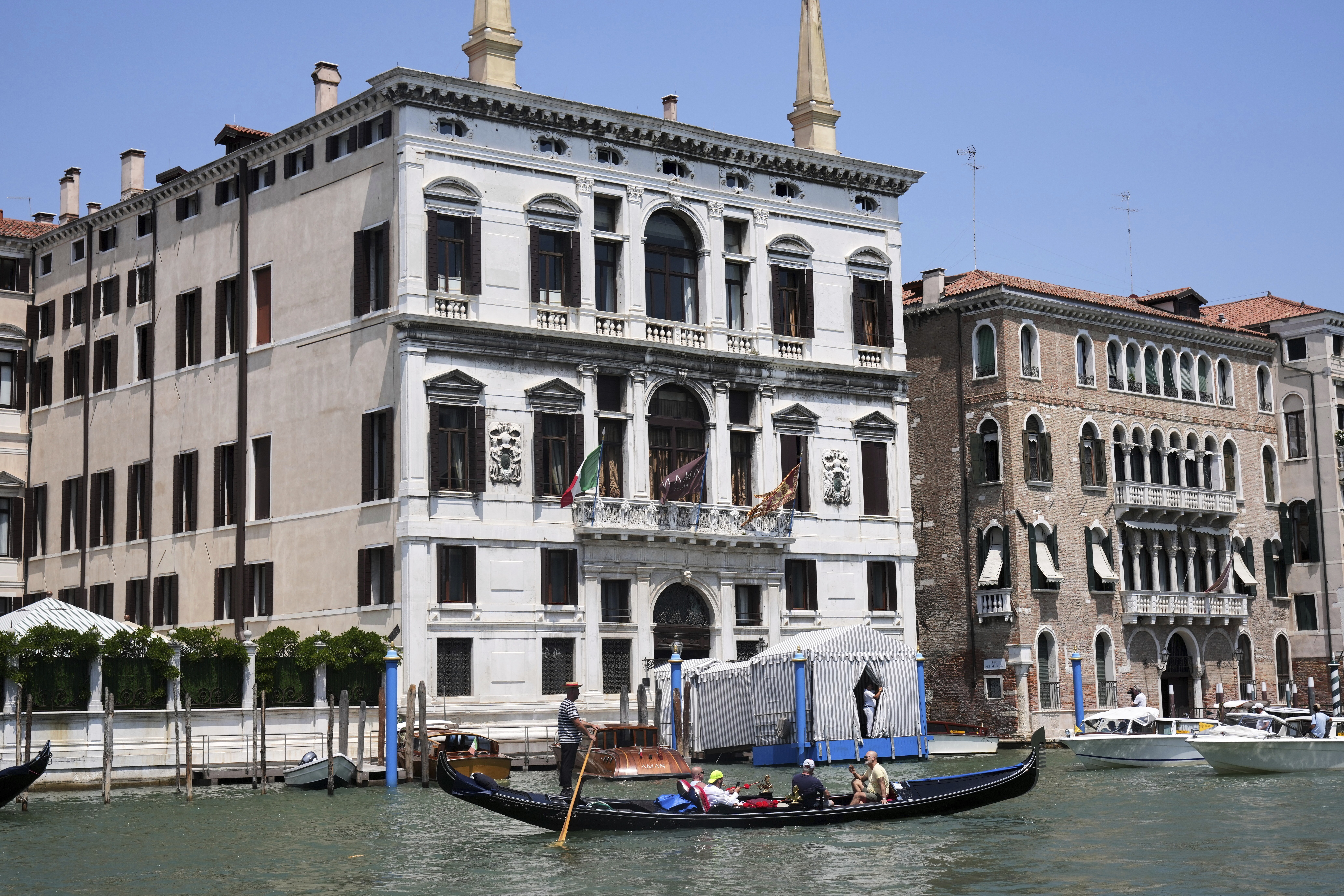 CORRECTS TO AMAN HOTEL NOT ANNAN A gondola sails past the Aman Hotel in Venice, Italy, on Thursday, June 26, 2025, ahead of festivities in the lagoon city reportedly linked to a wedding celebration for Jeff Bezos and Lauren Sánchez. (AP Photo/Antonio Calanni)