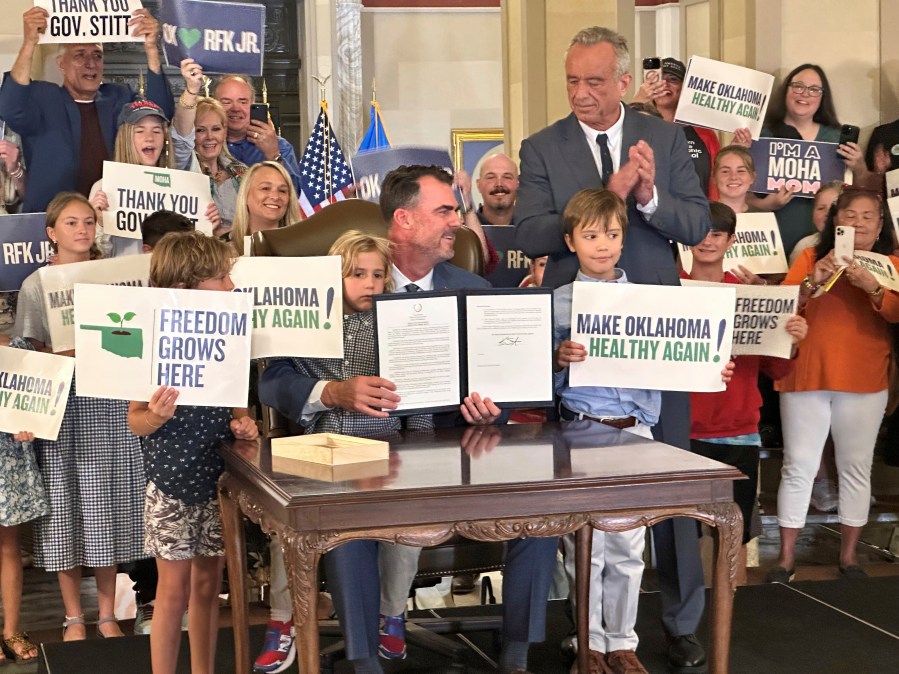 U.S. Secretary of Health and Human Services Robert F. Kennedy Jr. applauds after Oklahoma Gov. Kevin Stitt signed an executive order that aims to improve the health of Oklahomans on Thursday, June 26, 2025, at the Oklahoma State Capitol in Oklahoma City. (AP Photo/Sean Murphy)