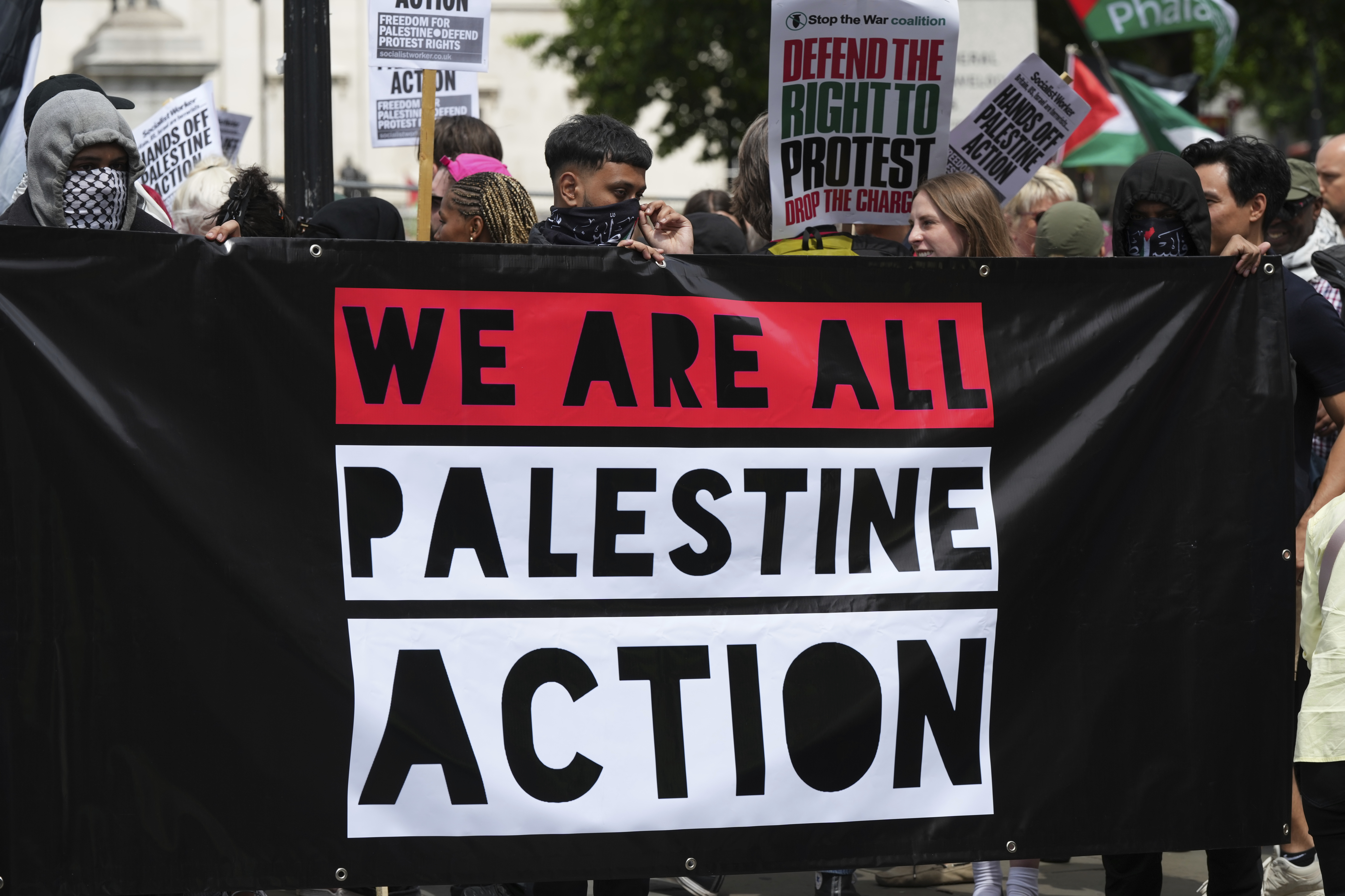 Demonstrators hold up a banner during a protest by Palestine Action group in London, Monday, June 23, 2025. (AP Photo/Frank Augstein)