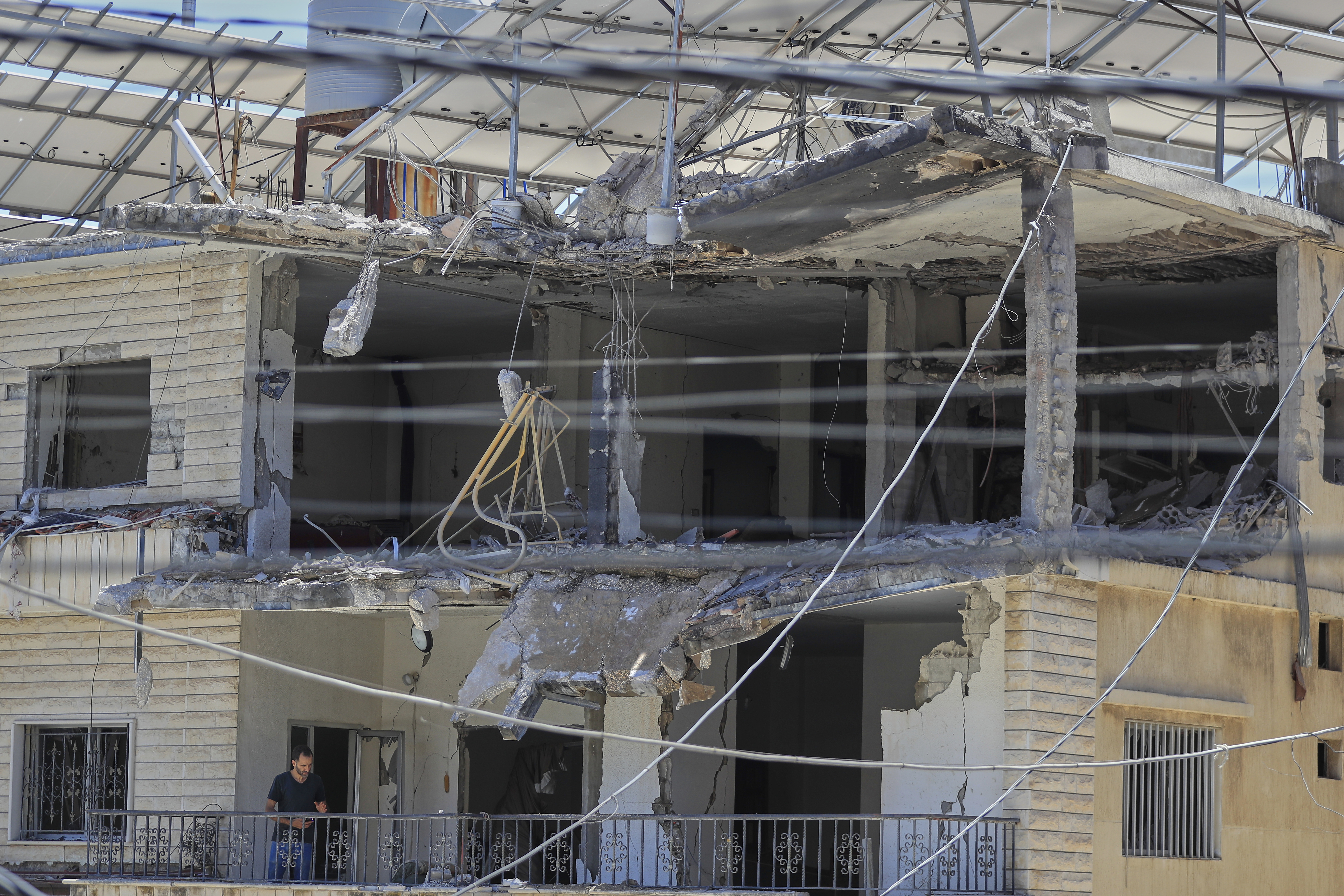A man checks his destroyed house that was hit in an Israeli airstrike in Nabatieh town, south Lebanon, Friday, June 27, 2025. (AP Photo/Mohammed Zaatari)