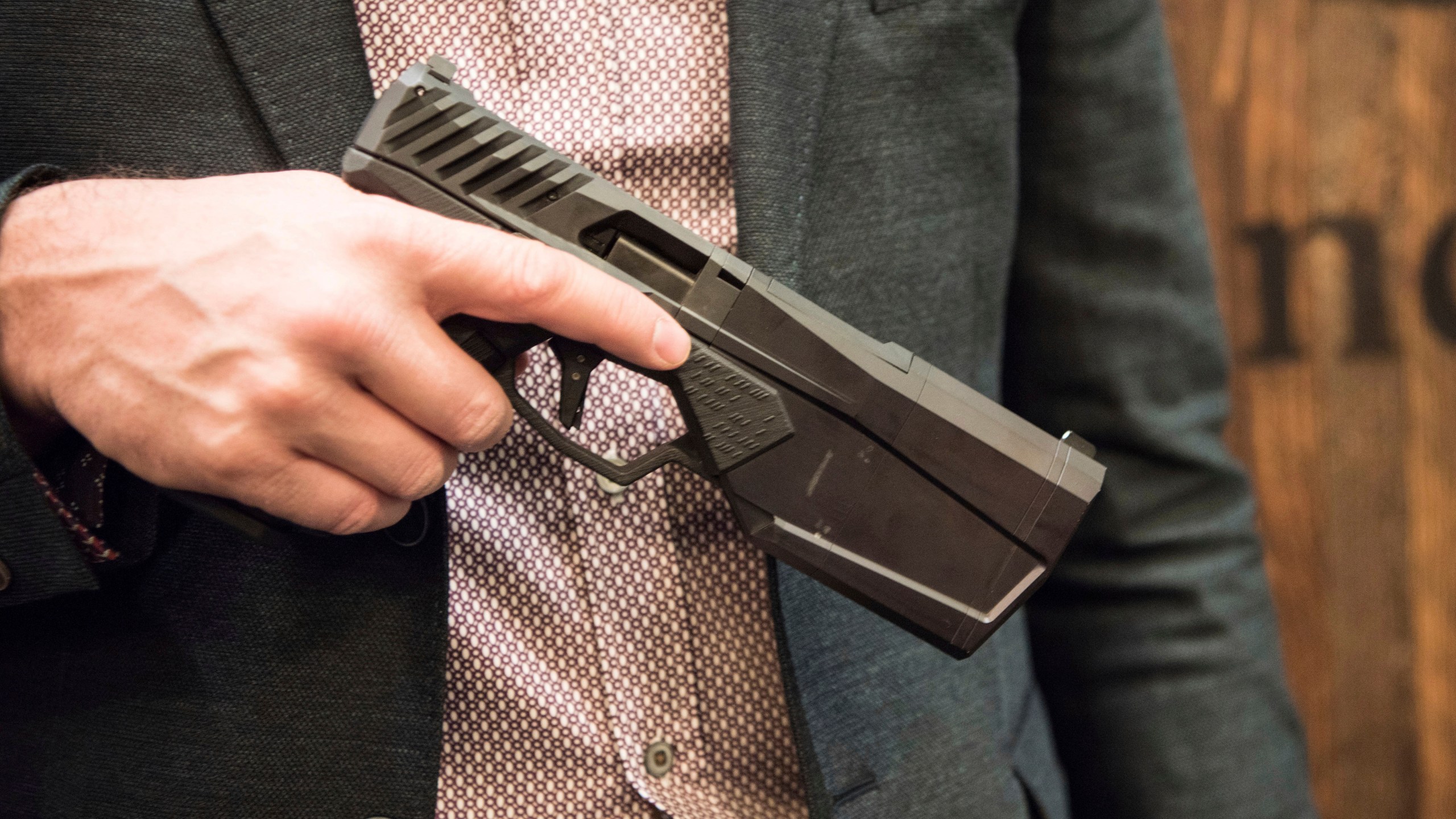 FILE - Josh Waldron, co-founder and CEO of SilencerCo, holds a 9mm handgun with a suppressor embedded into the barrel, Jan. 17, 2017, in Las Vegas. (AP Photo/Lisa Marie Pane, File)