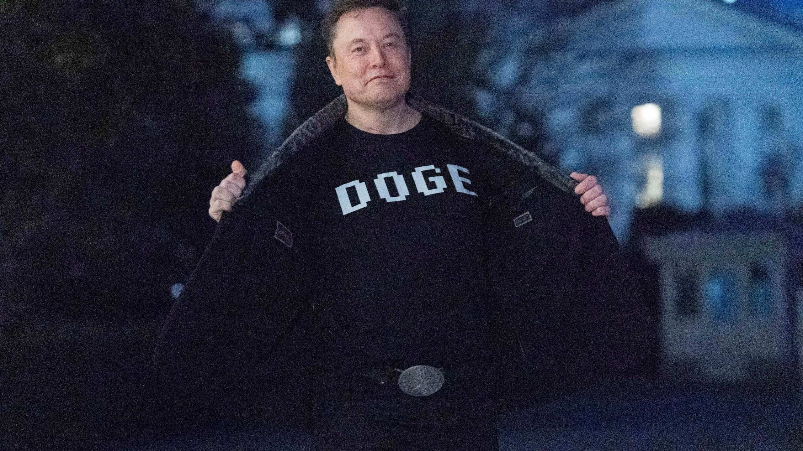 FILE - Elon Musk flashes his t-shirt that reads "DOGE" to the media as he walks on South Lawn of the White House, in Washington, March 9, 2025. (AP Photo/Jose Luis Magana, File)