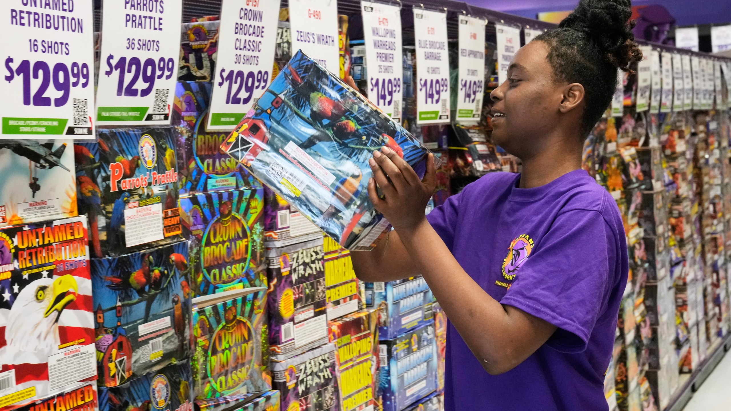 Devoyanna Taylor stocks shelves at a Phantom Fireworks in Youngstown, Ohio Wednesday, June 25, 2025. (AP Photo/Sue Ogrocki)