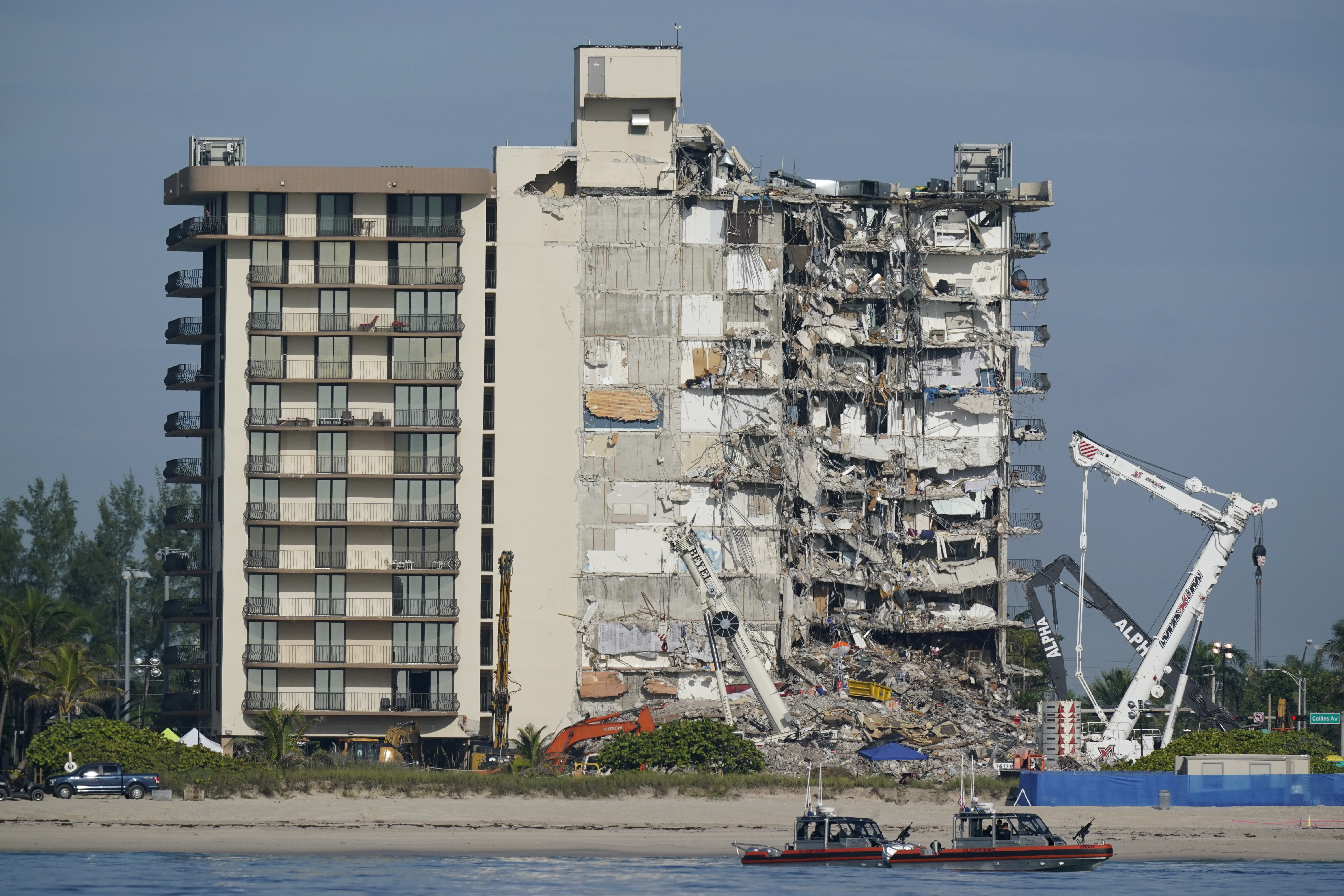 FILE - Coast Guard boats patrol in front of the partially collapsed Champlain Towers South condo building in Surfside, Fla., on July 1, 2021. (AP Photo/Mark Humphrey, File)