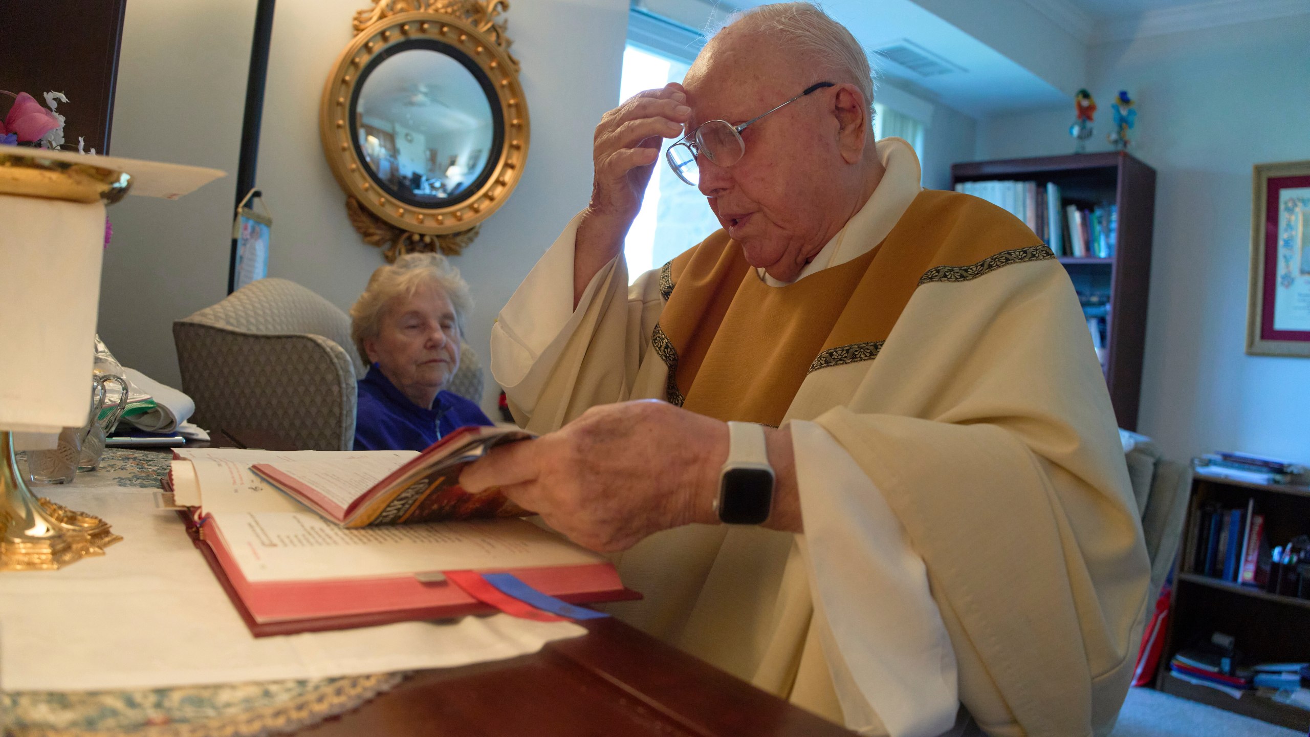 The Rev. James Kelly celebrates Mass at his apartment in the Normandy Farms Estates retirement community in Blue Bell, Pa., on Thursday, June 19, 2025. (AP Photo/Luis Andres Henao)