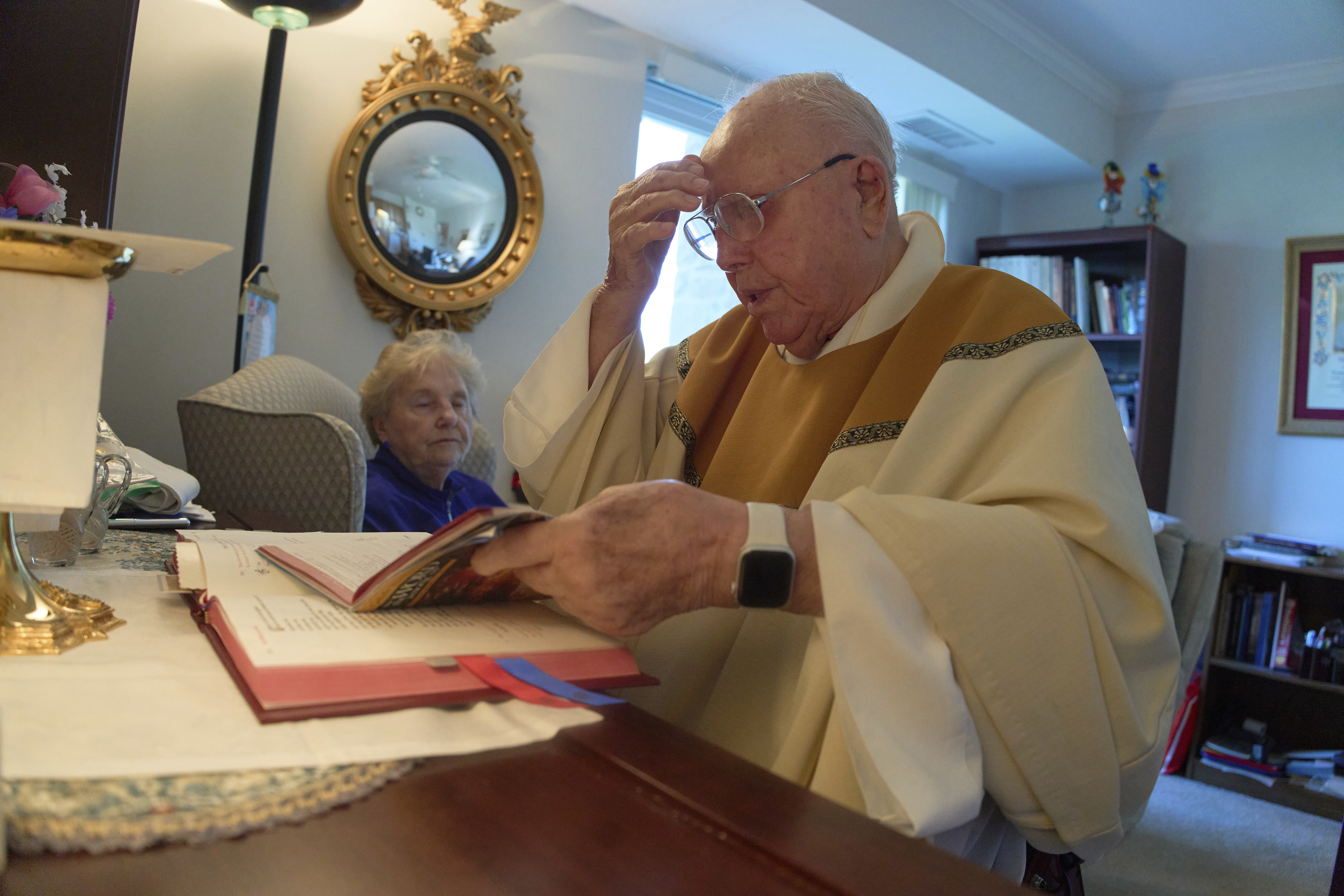 The Rev. James Kelly celebrates Mass at his apartment in the Normandy Farms Estates retirement community in Blue Bell, Pa., on Thursday, June 19, 2025. (AP Photo/Luis Andres Henao)