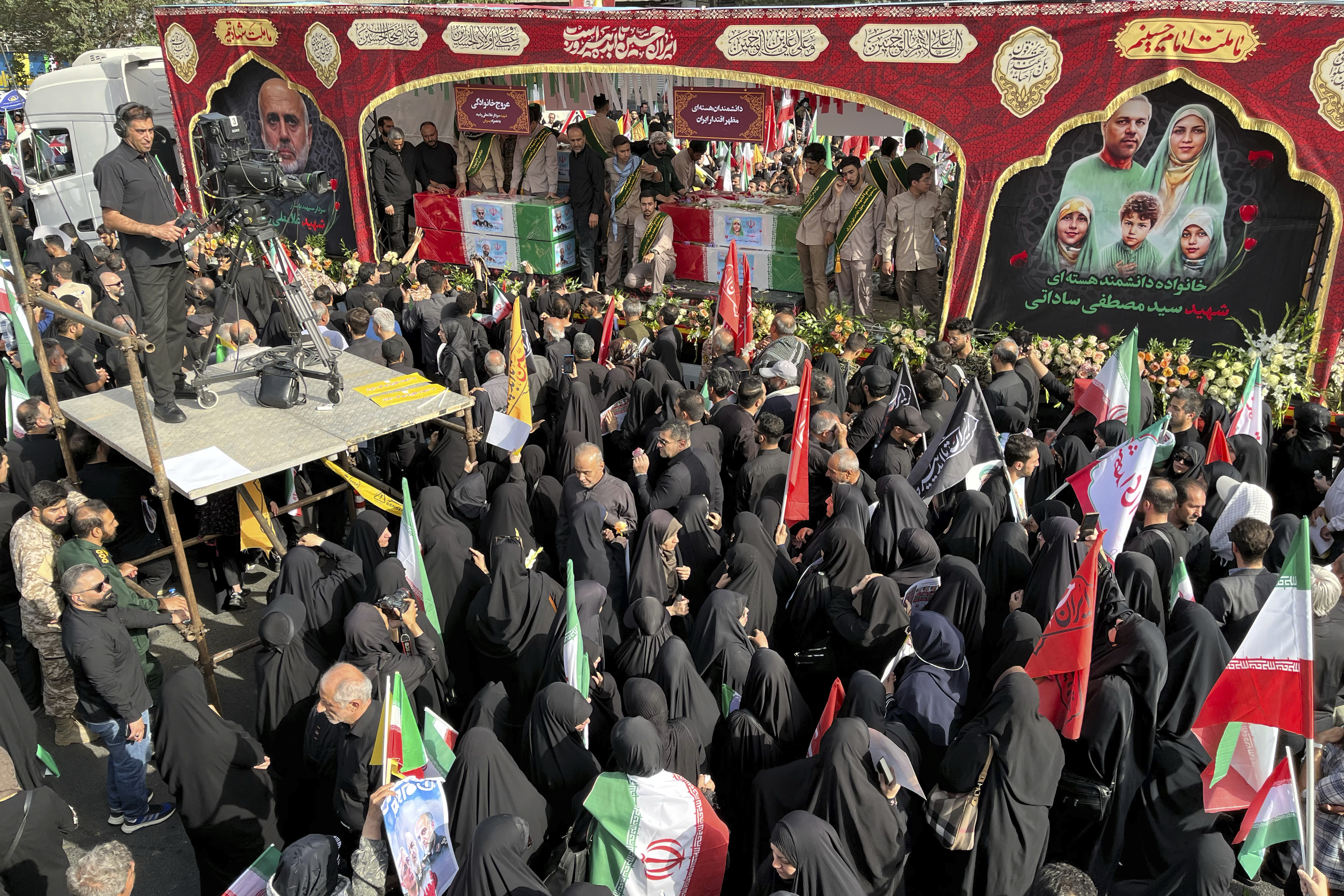 People mourn over the flag-draped coffins of Iranian army generals, nuclear scientists and their family members who were killed in Israeli strikes, during a funeral ceremony in Tehran, Iran, Saturday, June 28, 2025. (AP Photo/Vahid Salemi)