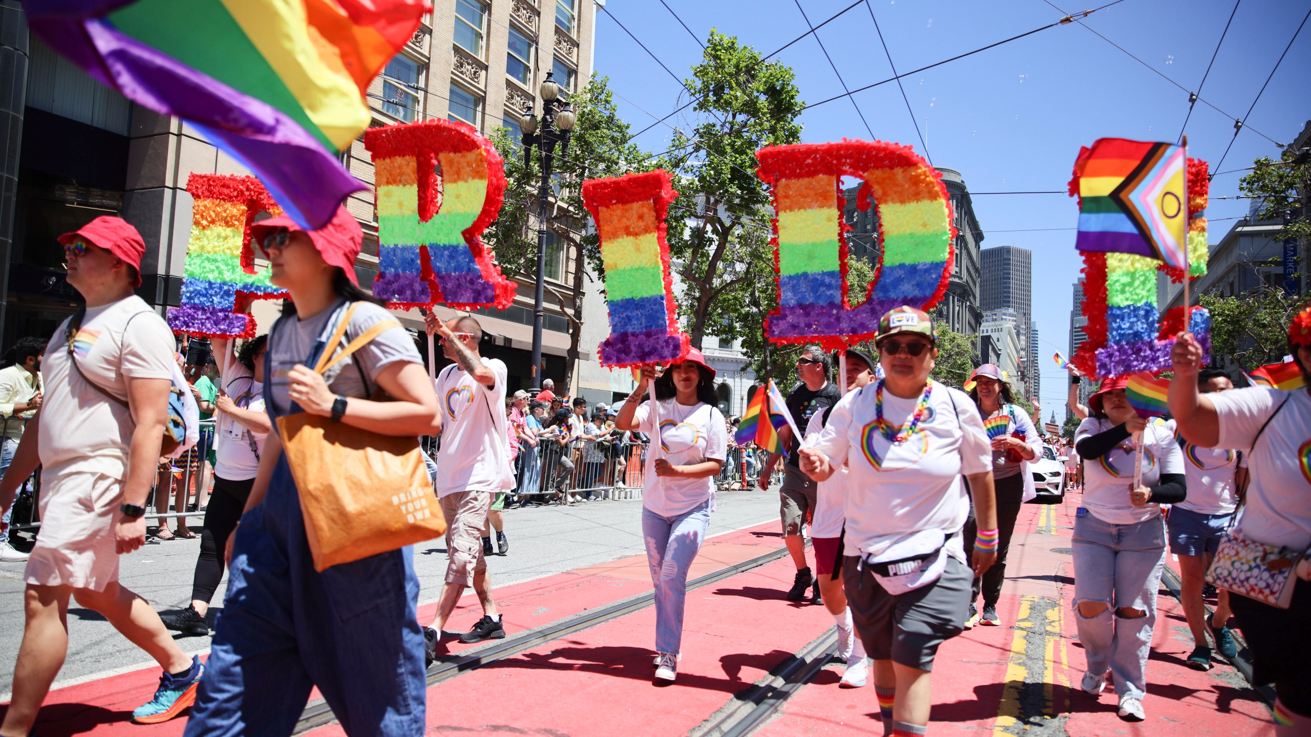 FILE - Revelers walk along Market Street during a Pride Parade, June 30, 2024, in San Francisco. (AP Photo/Ethan Swope, File)