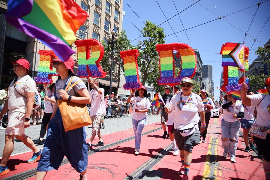FILE - Revelers walk along Market Street during a Pride Parade, June 30, 2024, in San Francisco. (AP Photo/Ethan Swope, File)