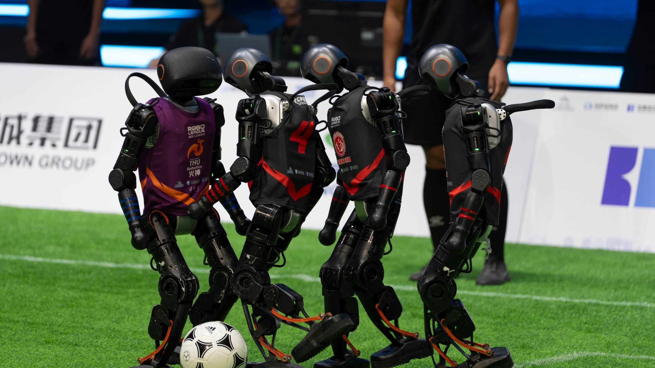 Teams compete using the T1 robots from Booster Robotics during the inaugural RoBoLeague robot soccer competition held in Beijing, Saturday, June 28, 2025. (AP Photo/Ng Han Guan)