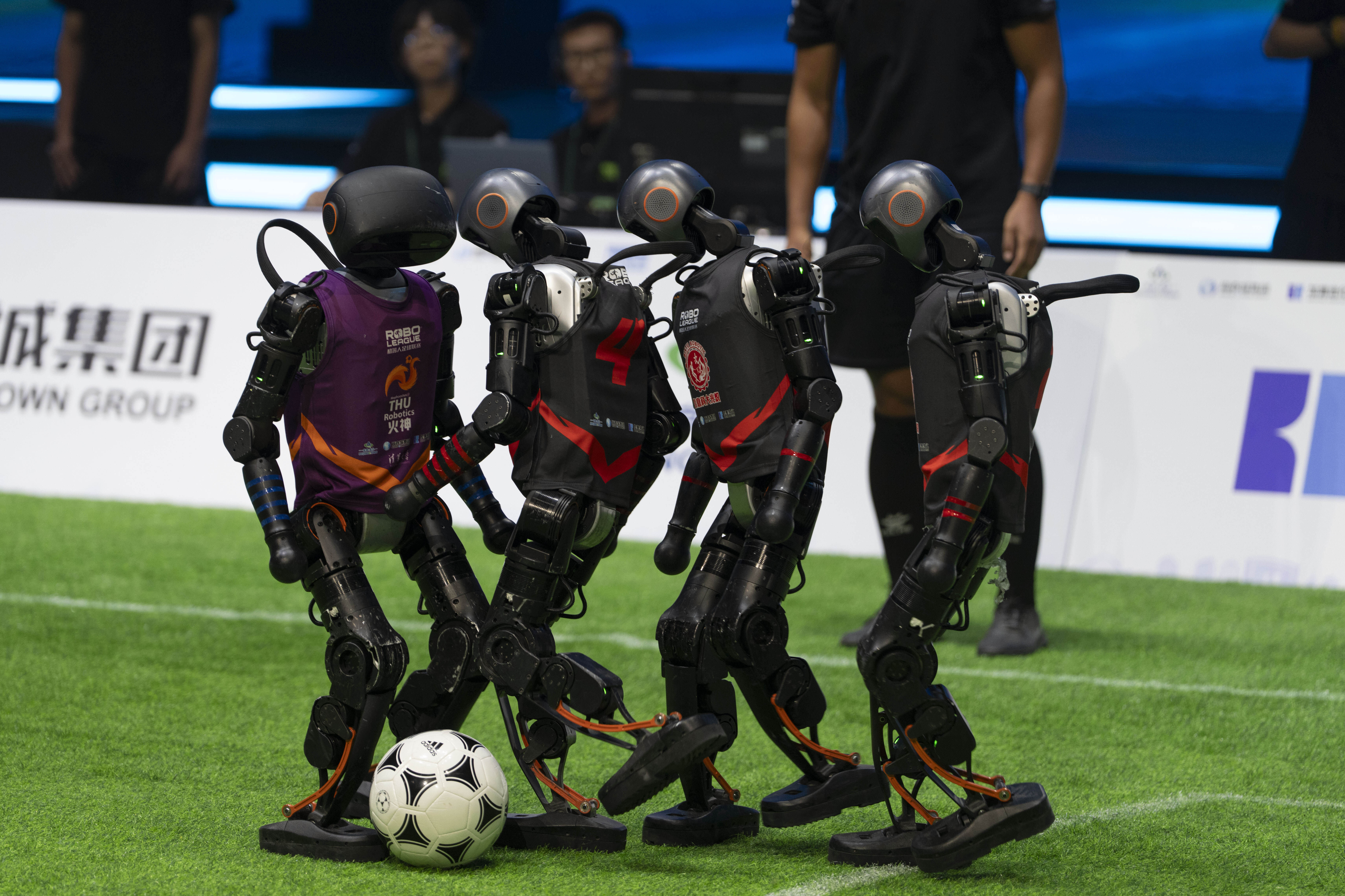 Teams compete using the T1 robots from Booster Robotics during the inaugural RoBoLeague robot soccer competition held in Beijing, Saturday, June 28, 2025. (AP Photo/Ng Han Guan)