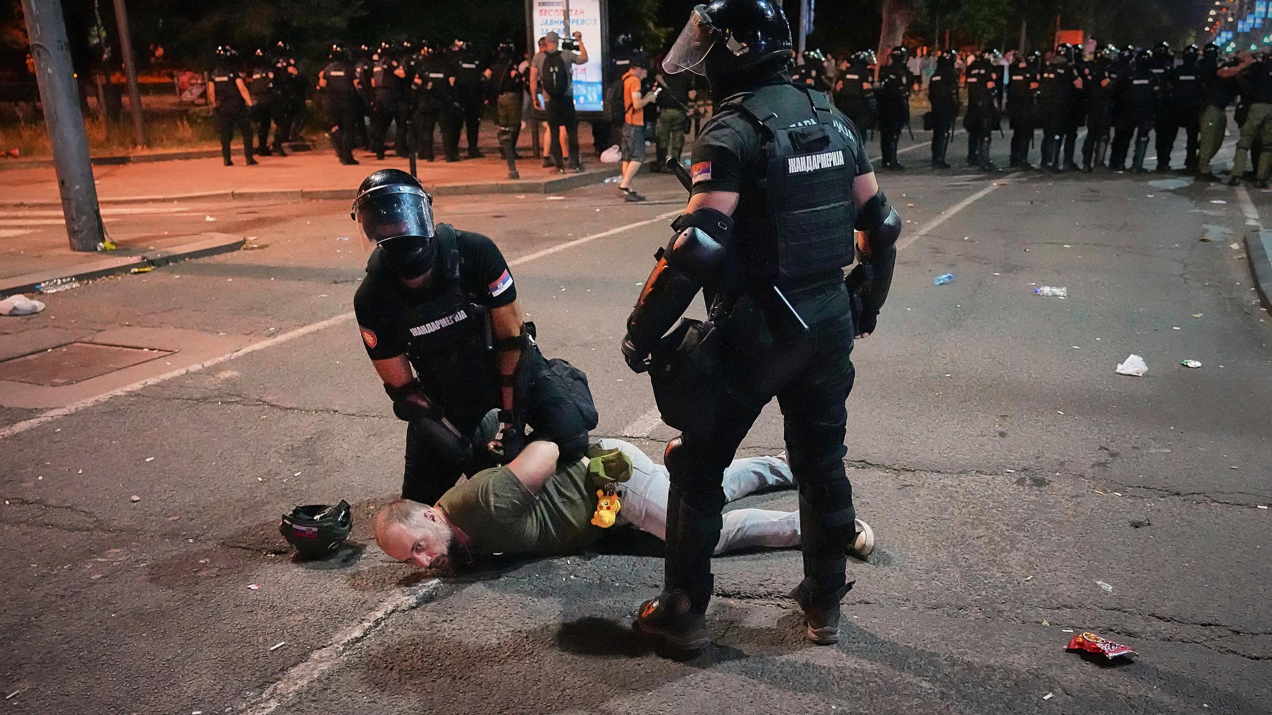 Riot police detain a man after charging protesters at the end of an anti-government rally pressing for an early election after nearly eight months of almost daily anti-corruption demonstrations that have shaken the populist government of President Aleksandar Vucic, in Belgrade, Serbia, Saturday, June 28, 2025. (AP Photo/Darko Vojinovic)