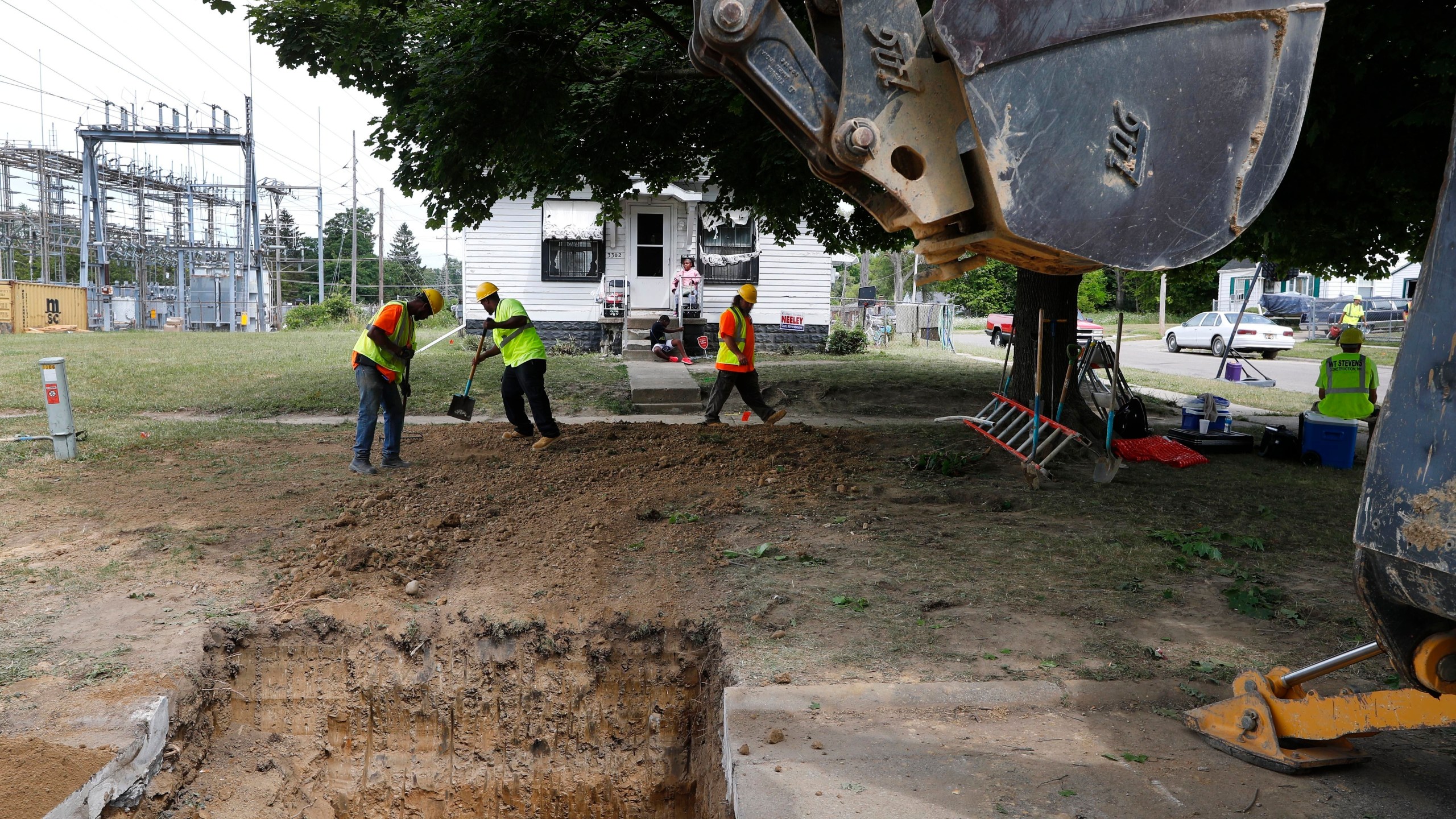 FILE - Workers back fill a hole used to replace lead pipe with copper water supply lines to a home in Flint, Mich., July 20, 2018. (AP Photo/Paul Sancya, File)