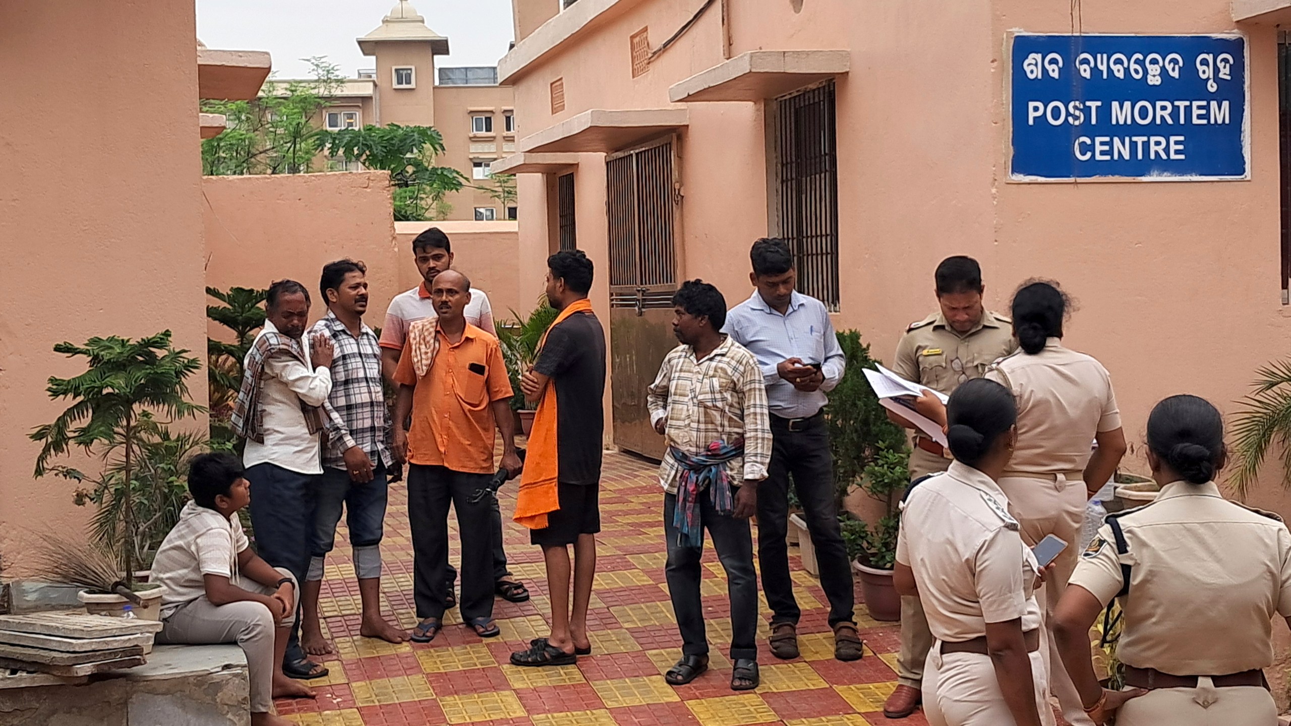 Police personnel and relatives of victims who lost their lives in a crowd surge at a Hindu religious procession wait outside a postmortem center at a government hospital in Puri, India, Sunday, June 29, 2025. (AP Photo)