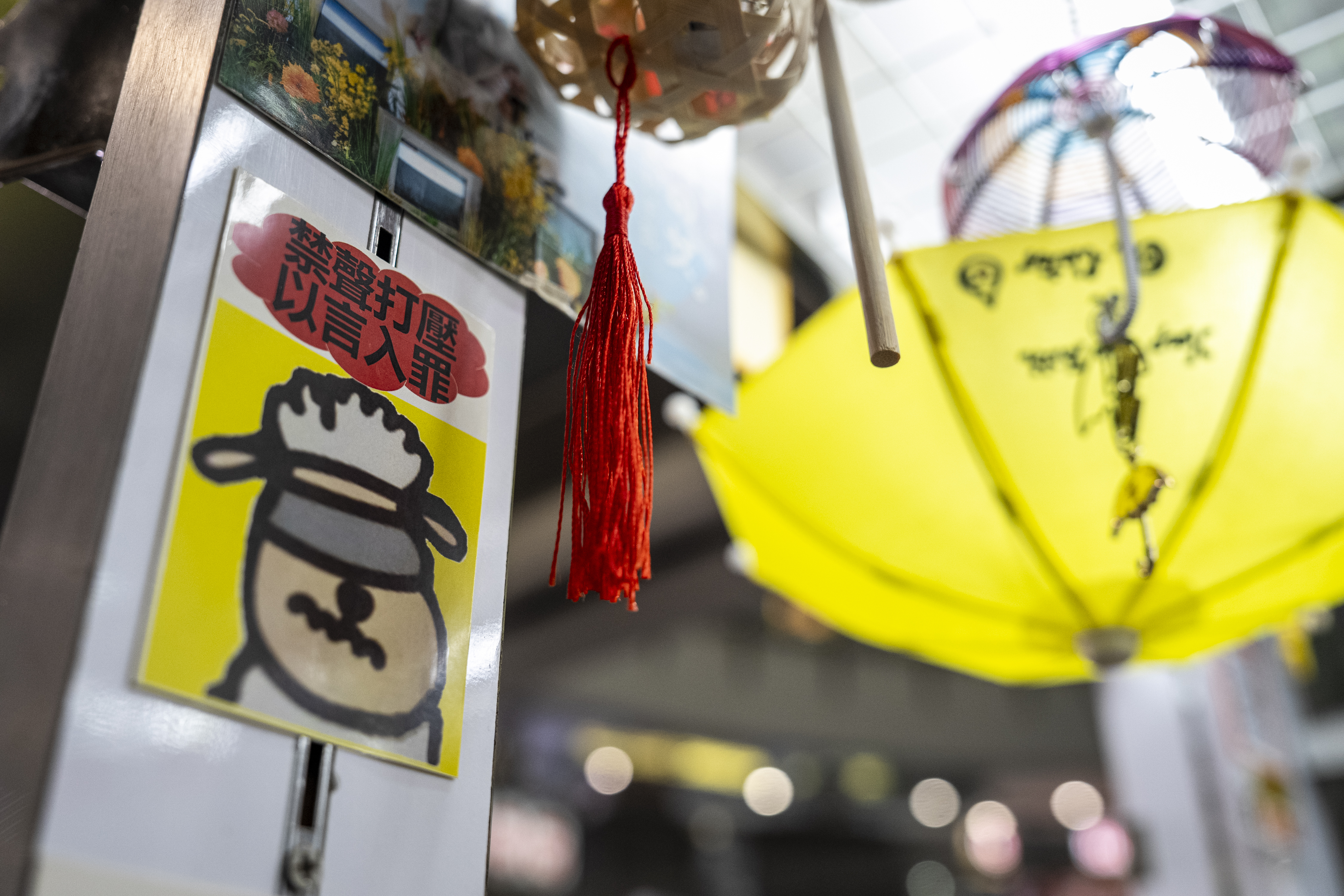 A sticker reads, "Silencing dissent and criminalizing speech," displayed at Chan Kim Kam's stall selling incense and essential oils in Hong Kong, Friday, June 20, 2025. (AP Photo/Chan Long Hei)