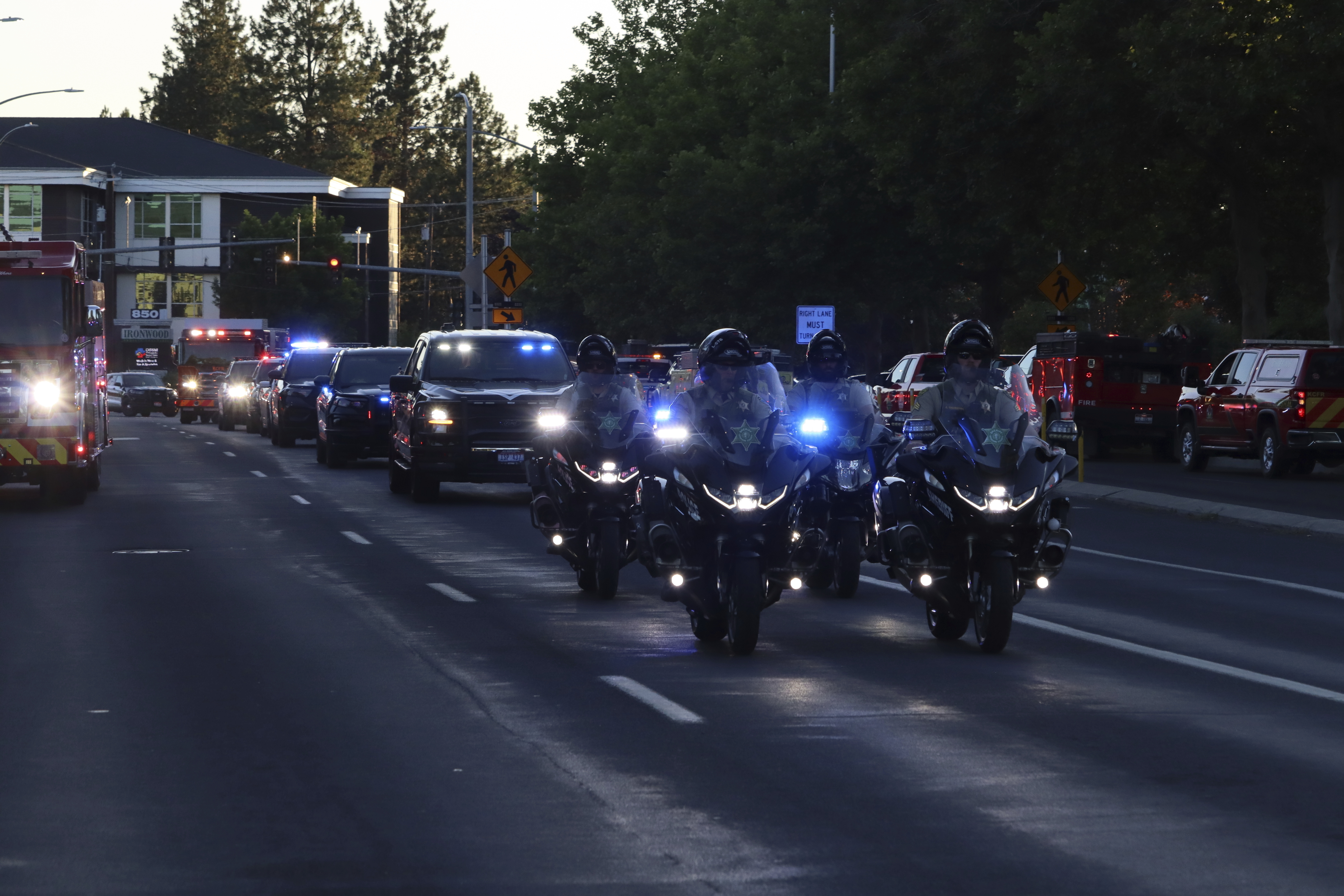 A procession from Kootenai Health headed to Spokane after a few firefighters were killed Sunday, June 29, 2025, when they were ambushed by sniper fire while responding to a blaze in a northern Idaho mountain community, in Coeur d’Alene, Idaho. (Bill Buley/Coeur D'Alene Press via AP)/