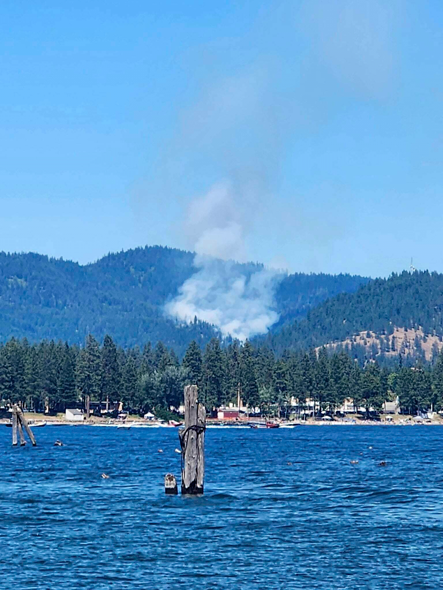 CORRECTS PHOTOGRAPHER Smoke rises from a fire near Lake Coeur d’Alene, Idaho, where responding firefighters were shot on Sunday, June 29, 2025. (C. Jones via AP)