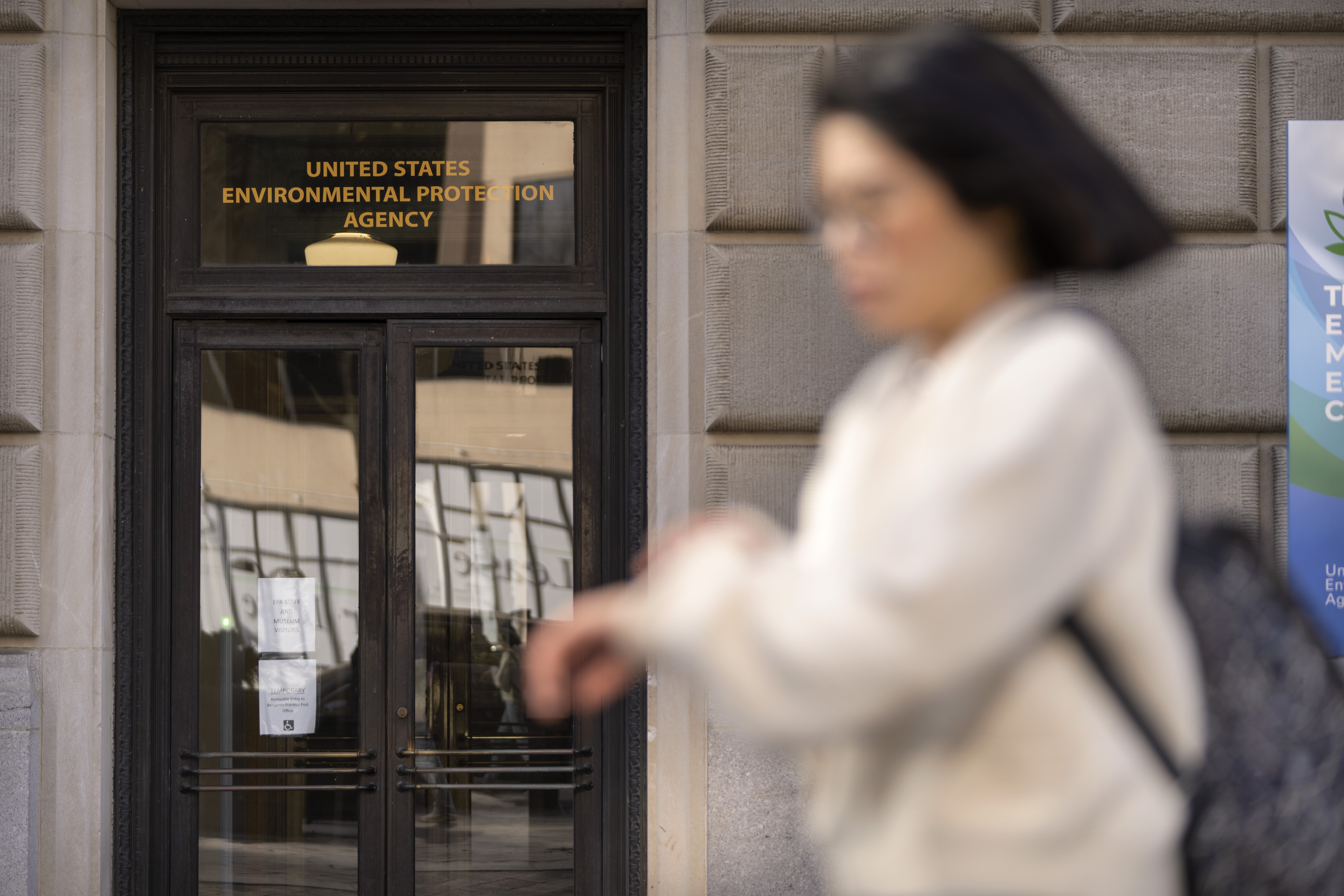 FILE - A person walks past the headquarters building of the Environmental Protection Agency, March 12, 2025, in Washington. (AP Photo/Mark Schiefelbein, File)