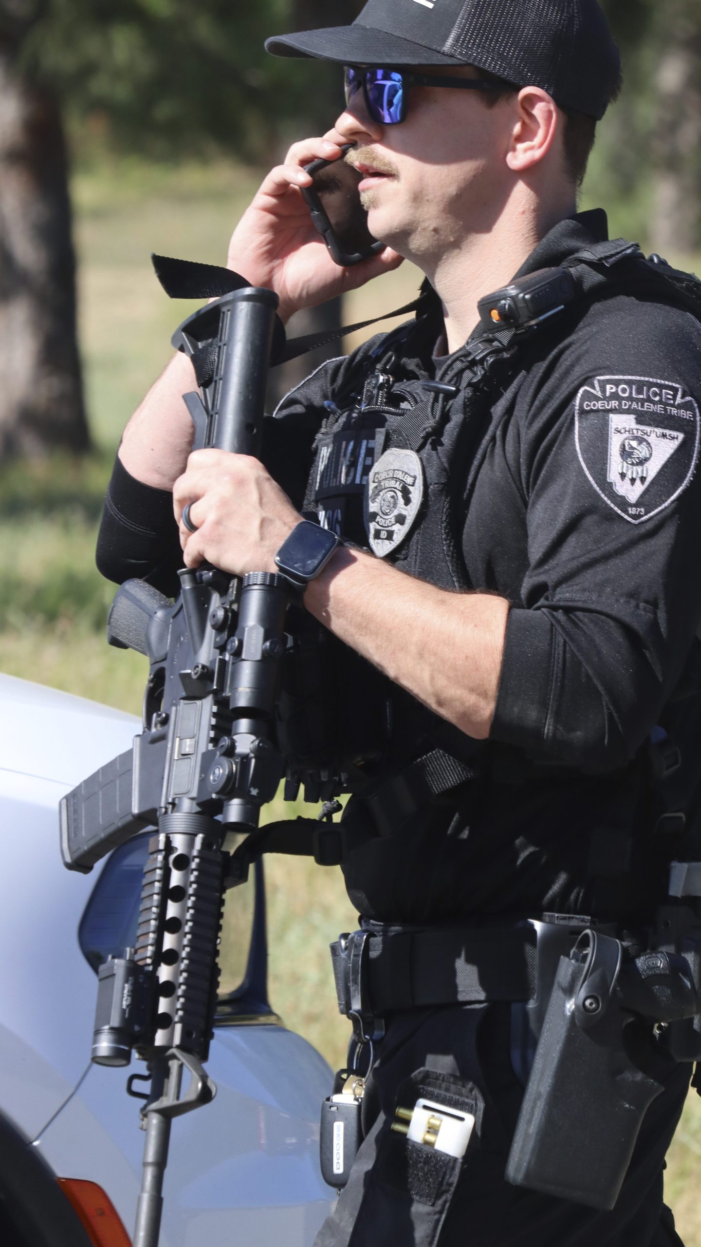 Coeur d'Alene police stage with other law enforcement at Cherry Hill Park off 15th Street on Sunday afternoon, June 29, 2025, following reports of an ambush shooting attack on Canfield Mountain, in Coeur d'Alene, Idaho. (Bill Buley/Coeur D'Alene Press via AP)