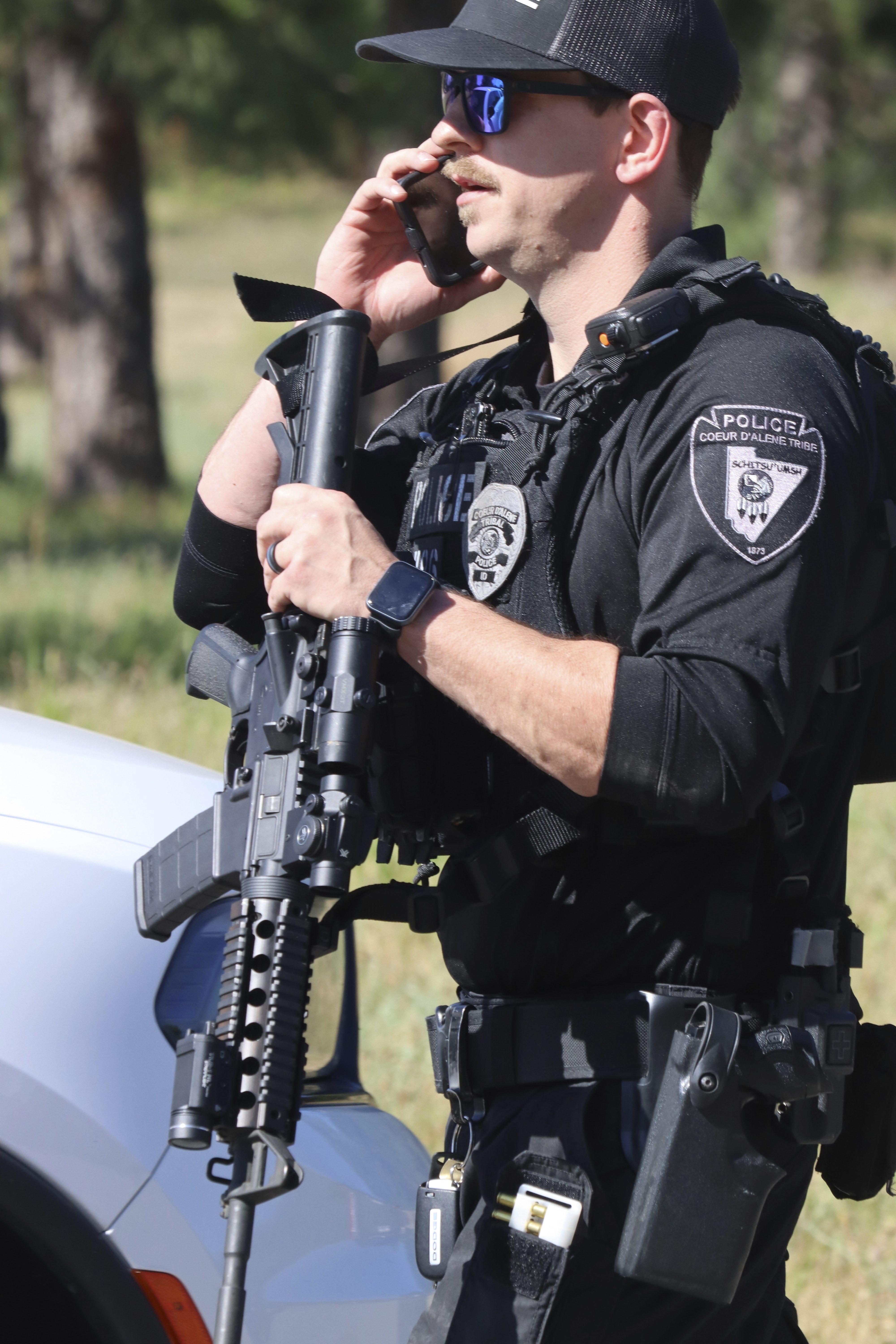 Coeur d'Alene police stage with other law enforcement at Cherry Hill Park off 15th Street on Sunday afternoon, June 29, 2025, following reports of an ambush shooting attack on Canfield Mountain, in Coeur d'Alene, Idaho. (Bill Buley/Coeur D'Alene Press via AP)