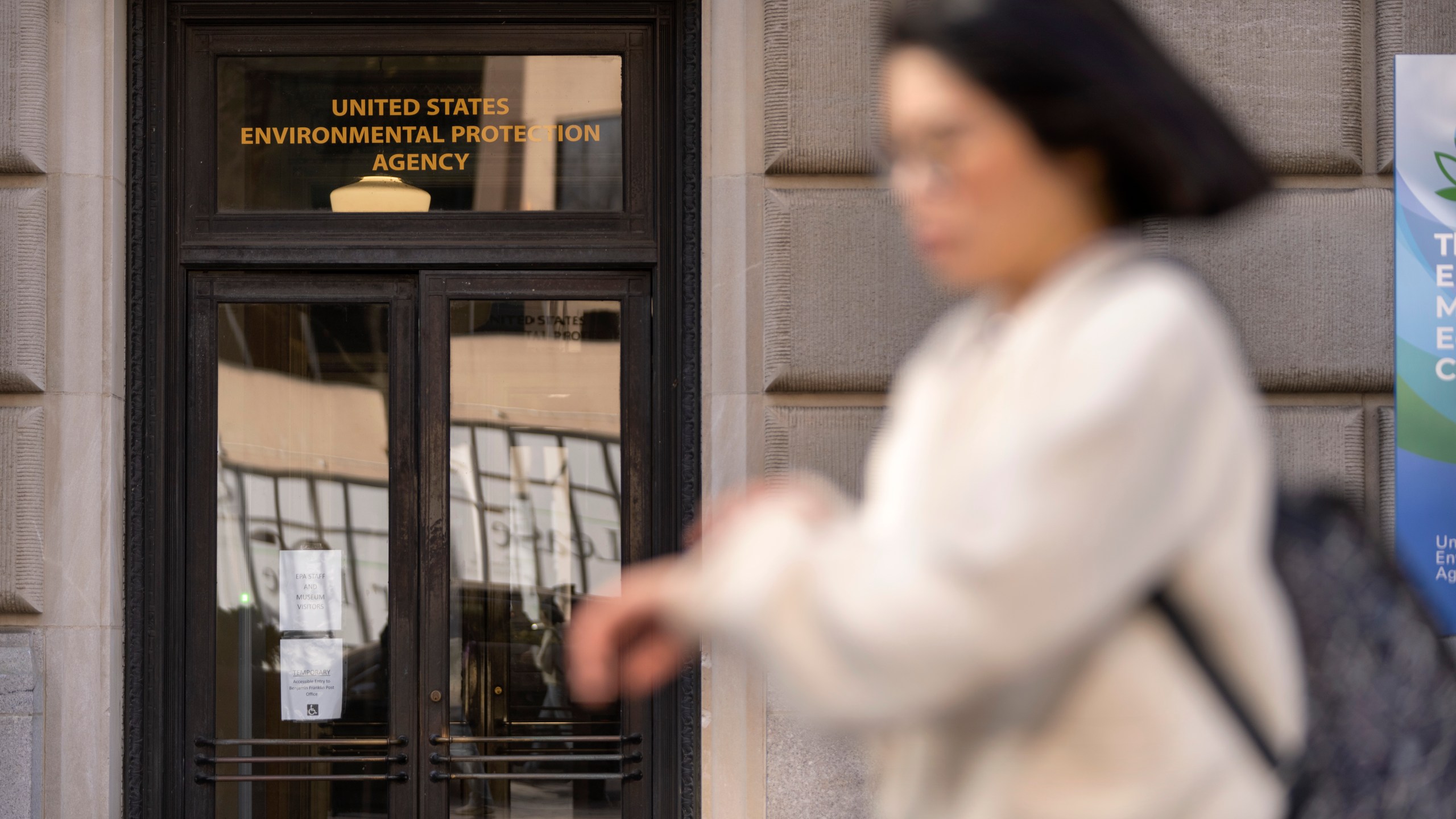 FILE - A person walks past the headquarters building of the Environmental Protection Agency, March 12, 2025, in Washington. (AP Photo/Mark Schiefelbein, File)