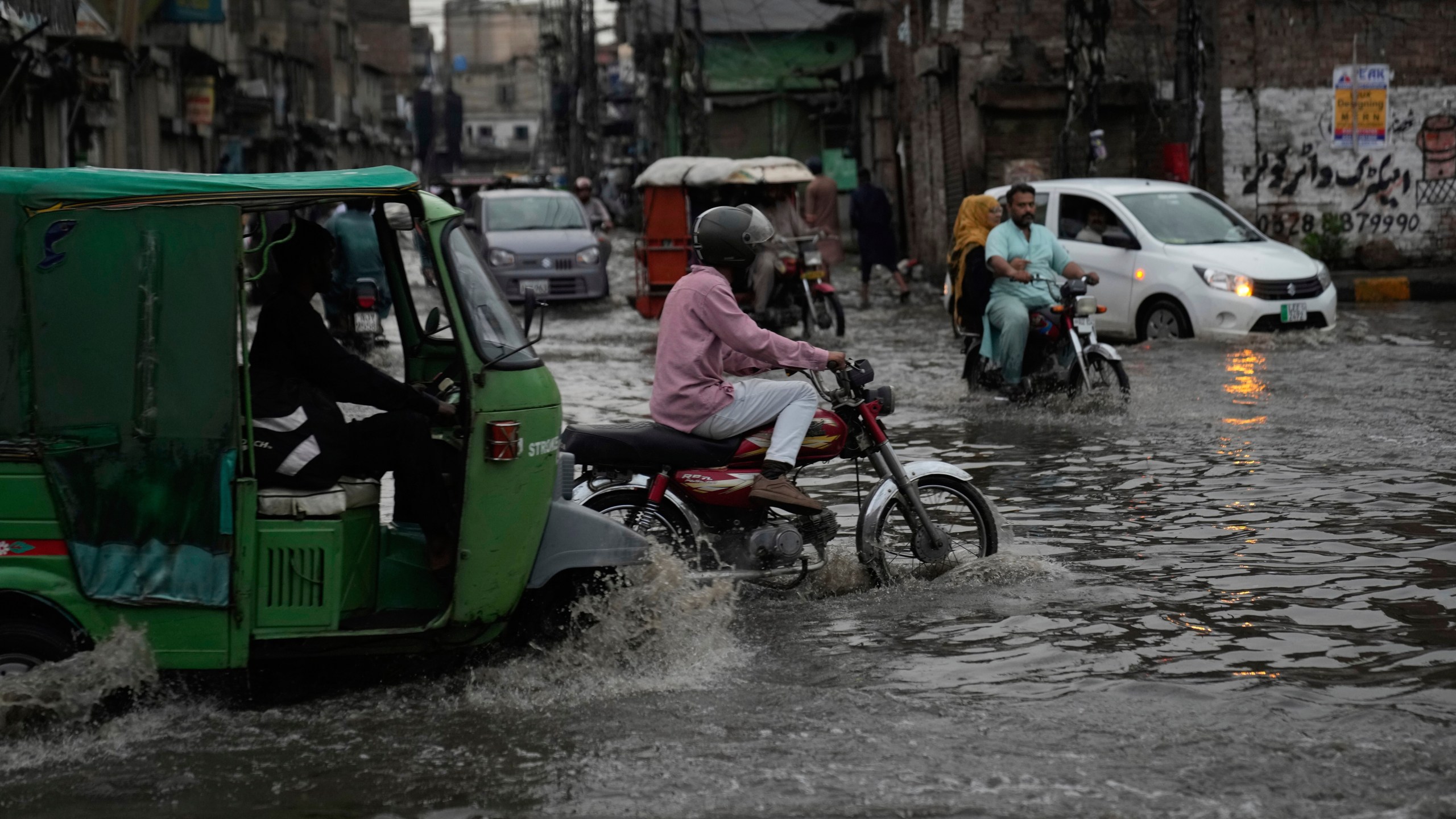 Motorists drive through a flooded road caused by heavy monsoon rains, in Lahore, Pakistan, Sunday, June 29, 2025. (AP Photo/K.M. Chaudary)
