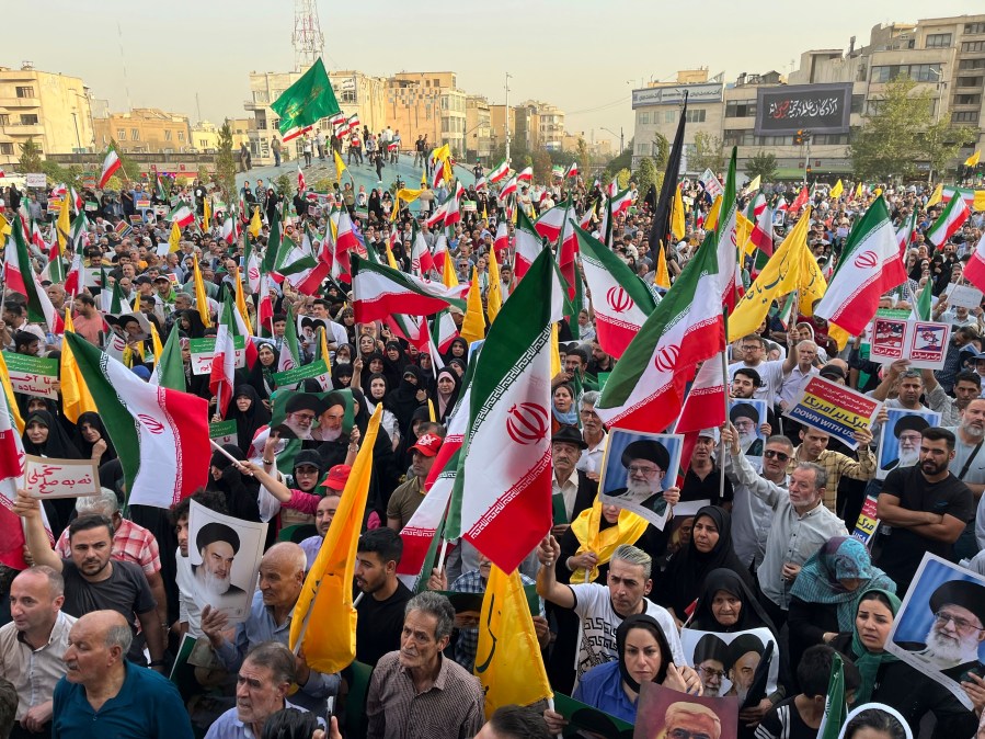 Protestors carry Iranian national flags and posters of the late revolutionary founder Ayatollah Khomeini and Supreme Leader Ayatollah Ali Khamenei, while chanting anti U.S. and Israel slogans, in Tehran, Iran, Tuesday, June 24, 2025. (AP Photo/Vahid Salemi)