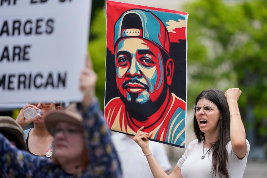 Brianna O'Keefe yells as she holds a portrait of Kilmar Obrego Garcia during a protest outside the federal courthouse Wednesday, June 25, 2025, in Nashville, Tenn. (AP Photo/George Walker IV)