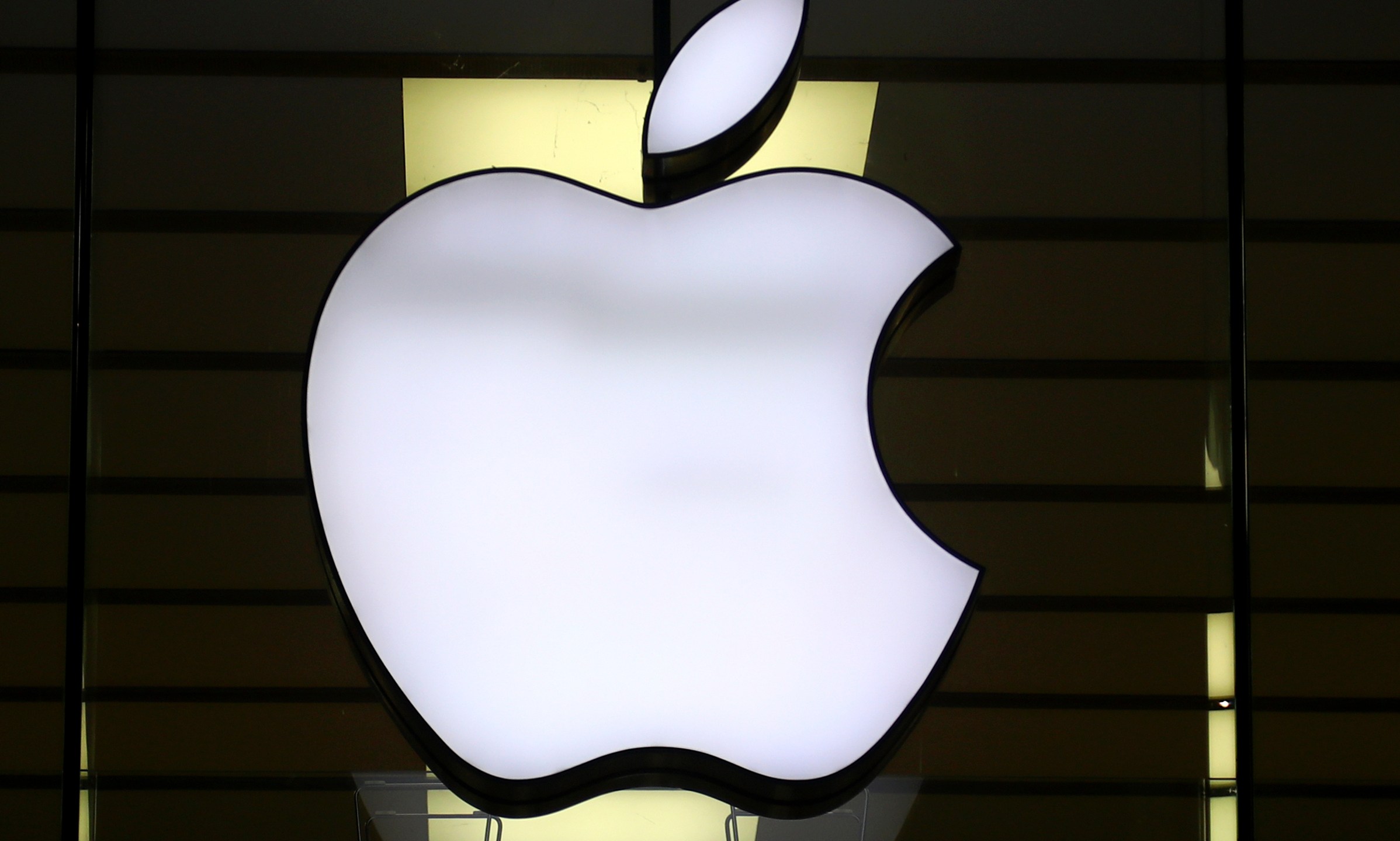 FILE - The Apple logo is illuminated at a store in the city center of Munich, Germany, Dec. 16, 2020. (AP Photo/Matthias Schrader, File)